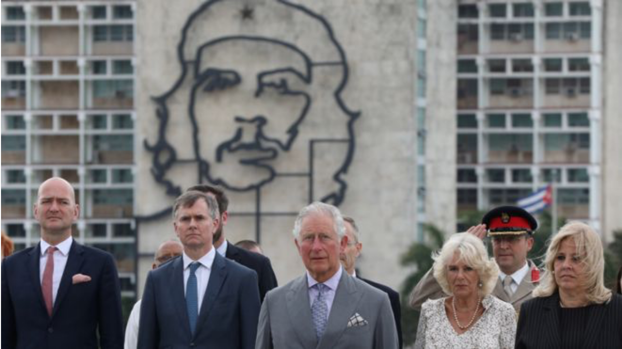 Their Royal Highnesses in Cuba posing near an image of Che Guevara. Photo: Reuters/ BBC News