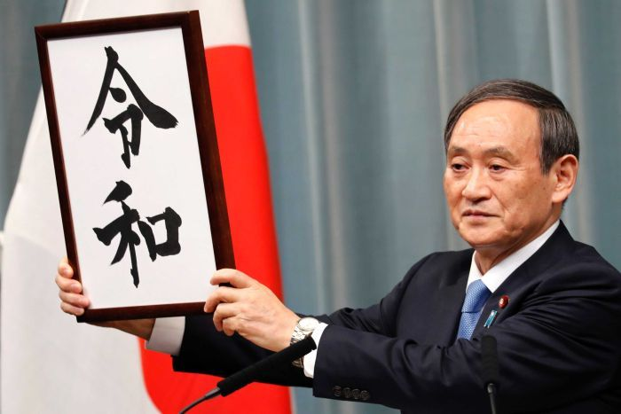 Chief Cabinet Secretary Yoshihide Suga holds up the characters of the new imperial era name, Reiwa, echoing then-Chief Cabinet Secretary Keizo Obuchi’s press conference in 1989 that revealed the era name Heisei to the public upon the death of Emperor Showa. Photo: AP/Eugene Hoshiko