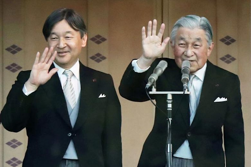 Crown Prince Naruhito (left) and his father Emperor Akihito (right) wave to the crowd at the Imperial Palace in Tokyo on Jan. 2, 2019, after the emperor delivered his final New Year’s address. Photo: AFP/Jiji Press