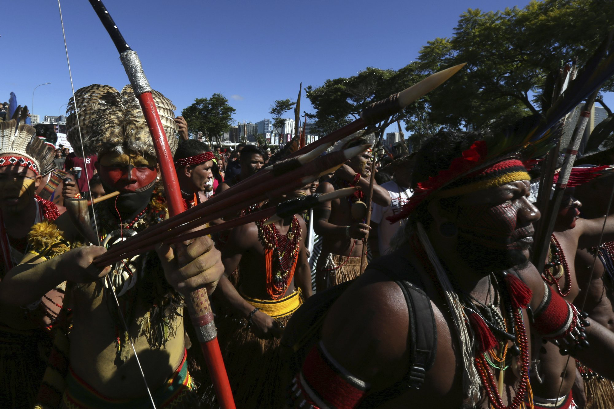 Indigenous Pataxo men carry their weapons during the Free Land Camp protest in Brasilia on Friday, April 26. The march protests the rollbacks of indigenous land and rights under Bolsonaro. Photo: AP Photo /Eraldo Peres.
