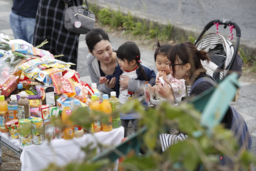 People pay respects at a makeshift memorial on Thursday, May 9, 2019, to the victims of the two-car collision that claimed two lives and injured over a dozen others the day prior. Photo: KYODO