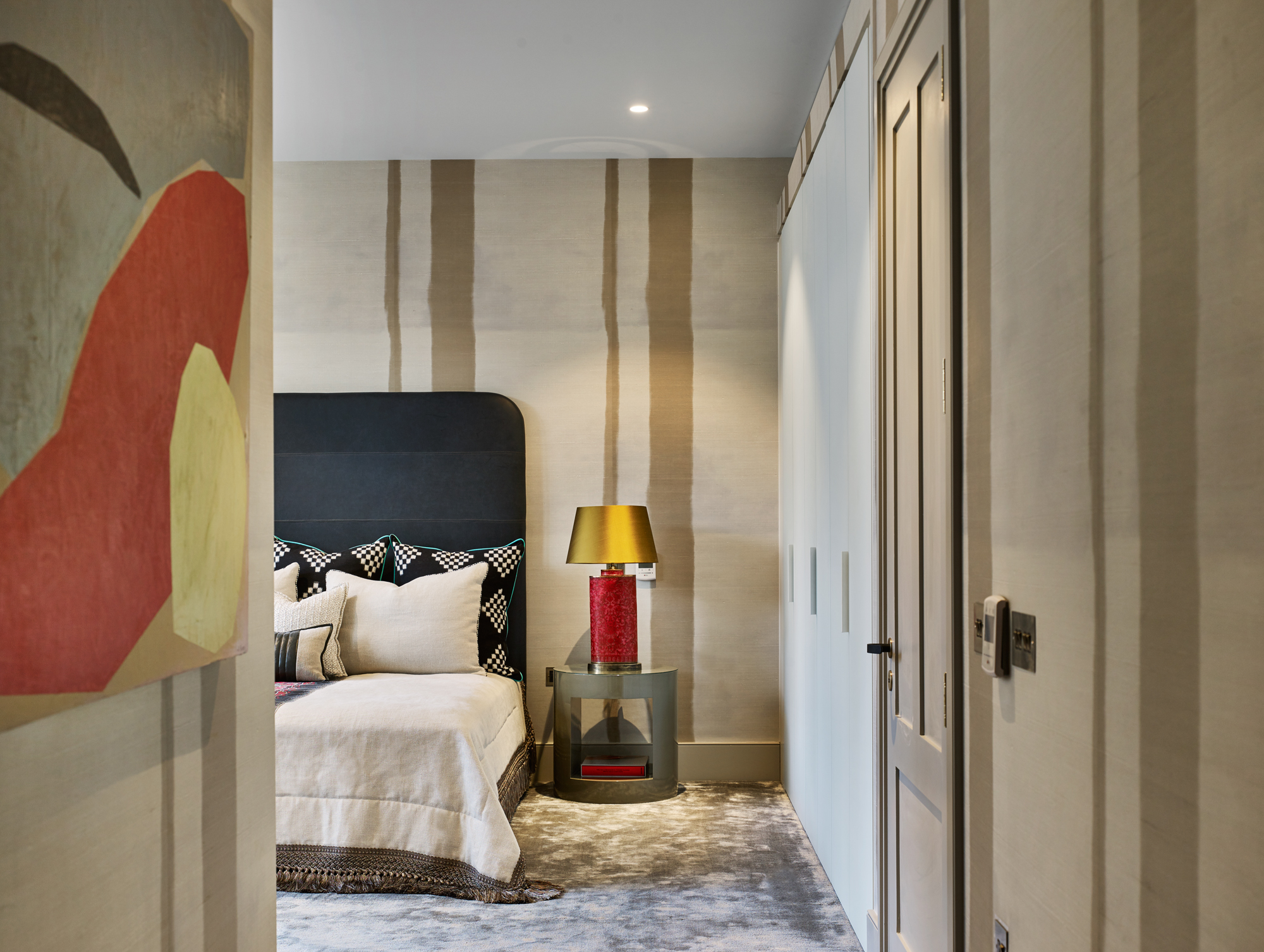 The unusual wallcovering is inspired by Sri Lanka, the custom bedding from France and the cloisonné enamelled lamps from China. The master bedroom and windows were oversized that they could handle the many different cultural references in one room and things were kept decidedly contemporary with the bespoke leather headboard as the anchor. 