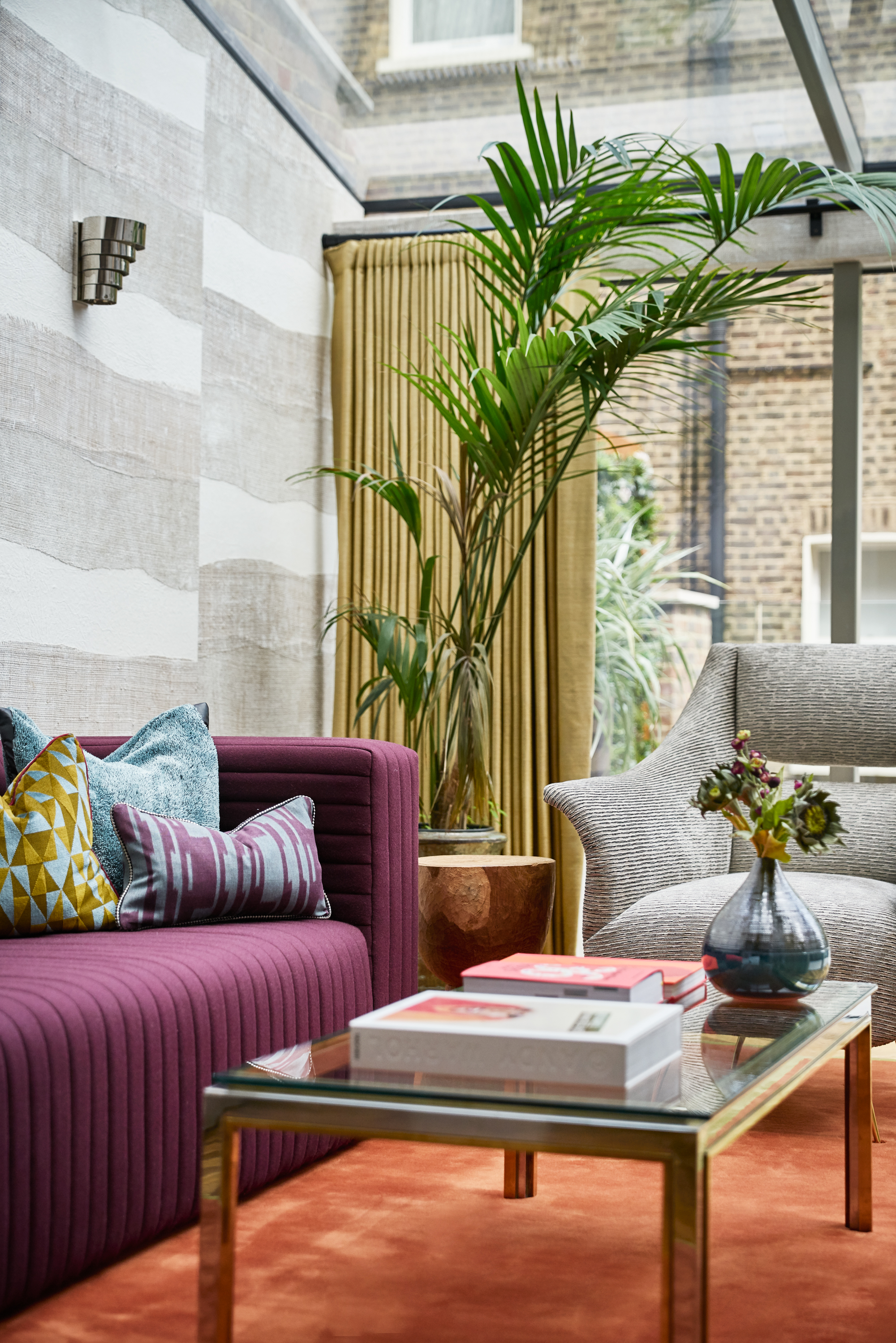 Planning permission was secured for a contemporary glass extension which opens onto a large terrace to create a 360-degree indoor/outdoor entertaining space during warmer months. The bespoke furniture and area rug was made specifically for the family room in a rust orange to give it that earthy 70's vibe. The wallcovering mimicked the movement in the area rug in the dining room and the textiles connect the fundamental colours between the two spaces.