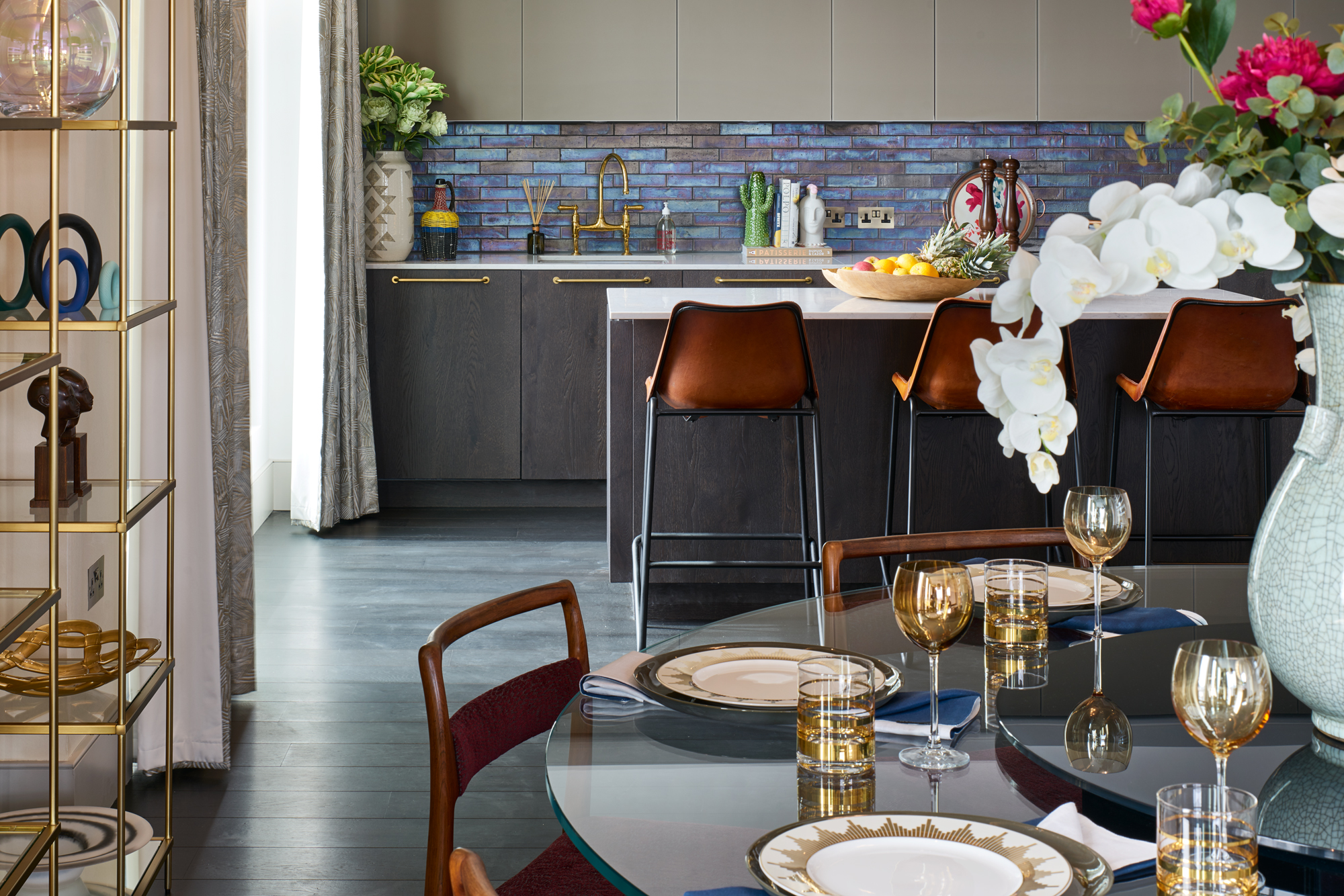 The kitchen was semi-customised by adding brass handles and a bespoke veneer to blend seamlessly with the flooring. The upper cabinets were sandblasted glass painted in a RAL colour. The backsplash tiles went through many prototypes before getting the iridescent petrol cast just right!