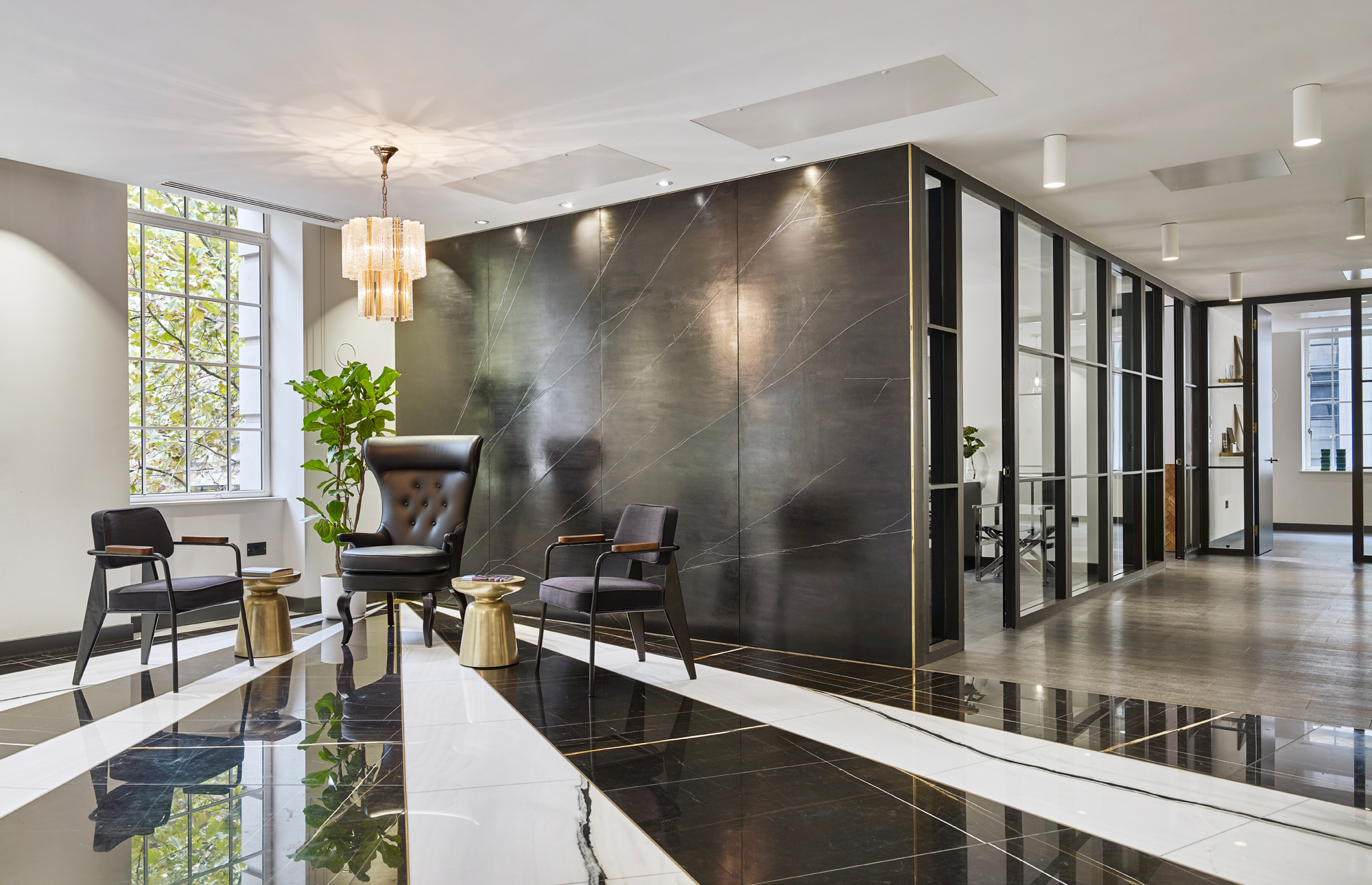 A striking graphic black and white marble floor immediately draws visitors off the lift and to the seating area of reception.