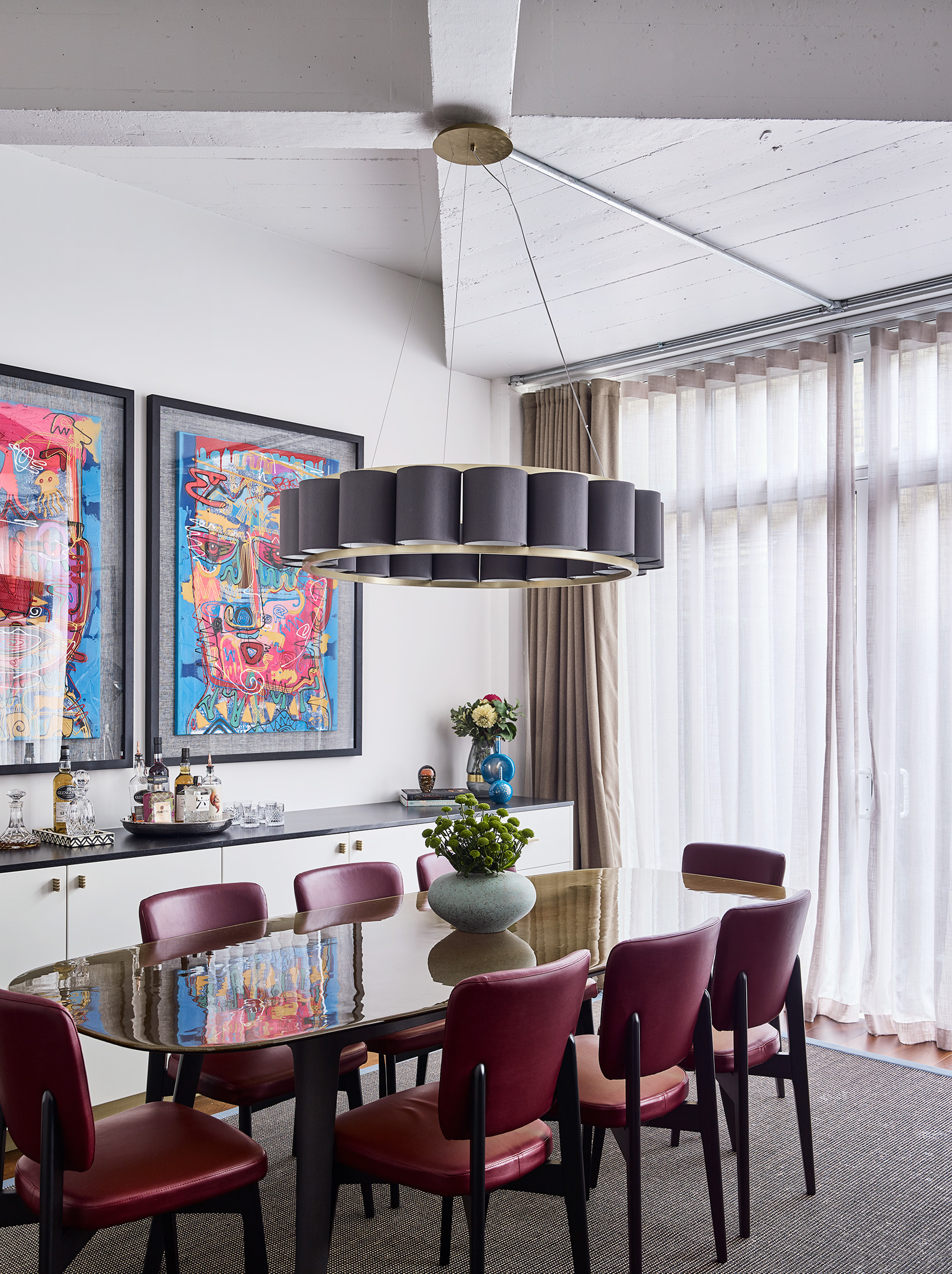 The amber coloured dining table and club red faux leather chairs were the primary colours pulled from the paintings that were used throughout the home to tie the rooms together.