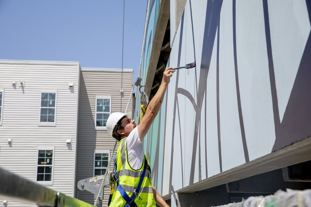  Artist Nicholas Zimboro paints mural for GMU's new off-campus housing The Flats. Photo by:  Sierra Guard/Creative Services/George Mason University 