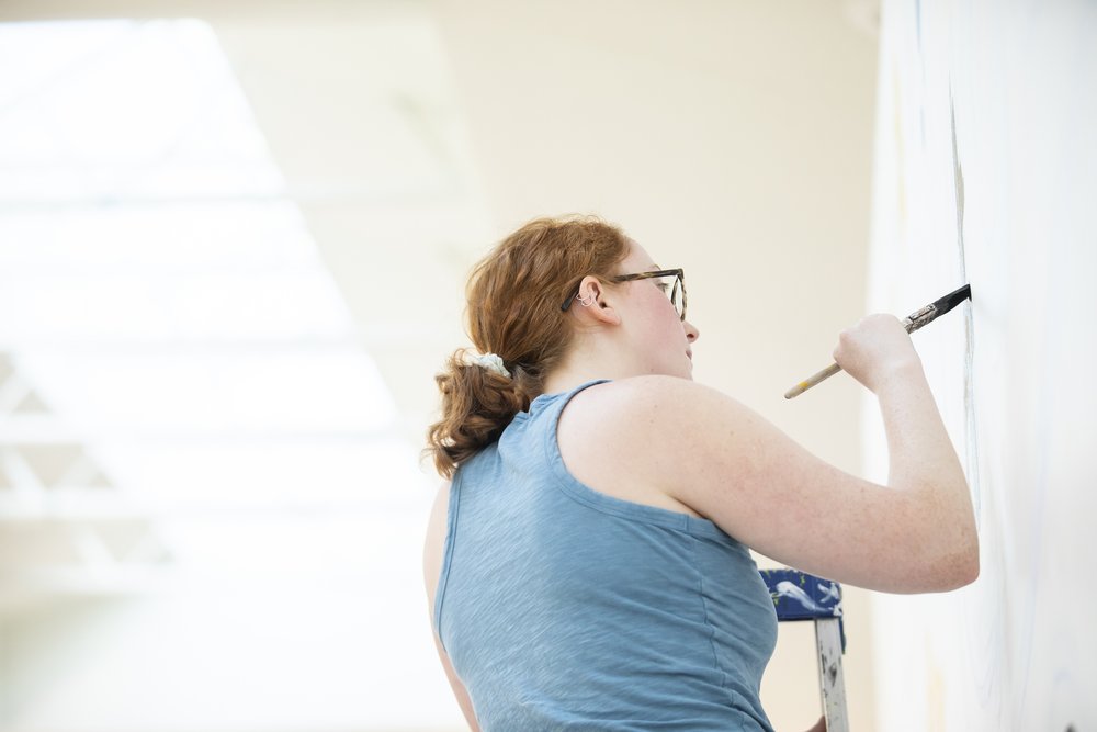  Artist Emma Dardis paints mural for Manassas Mall. Organized by Murals at Mason. Photo by:  Sierra Guard/Creative Services/George Mason University 