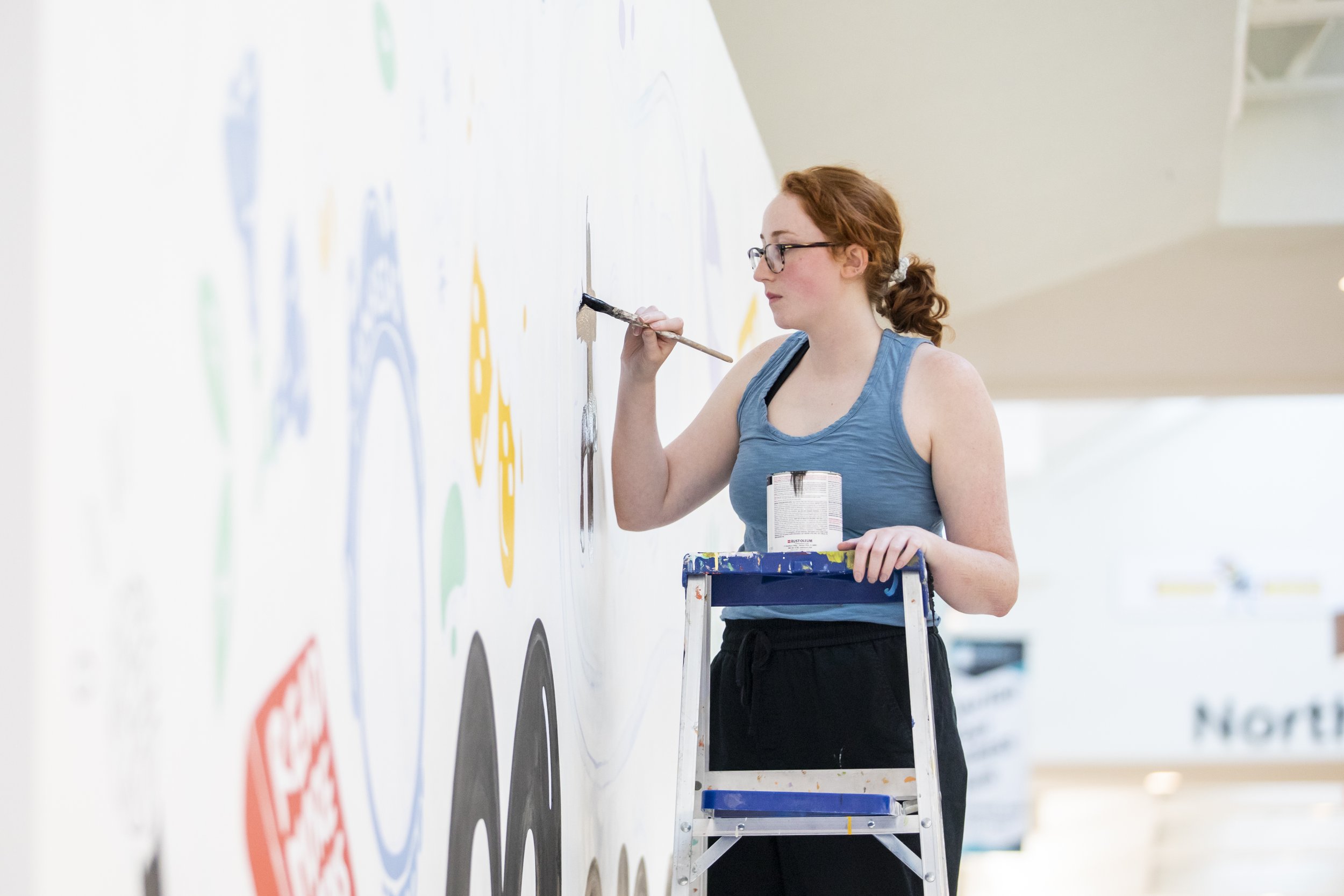  Artist Emma Dardis paints mural for Manassas Mall. Organized by Murals at Mason. Photo by:  Sierra Guard/Creative Services/George Mason University 