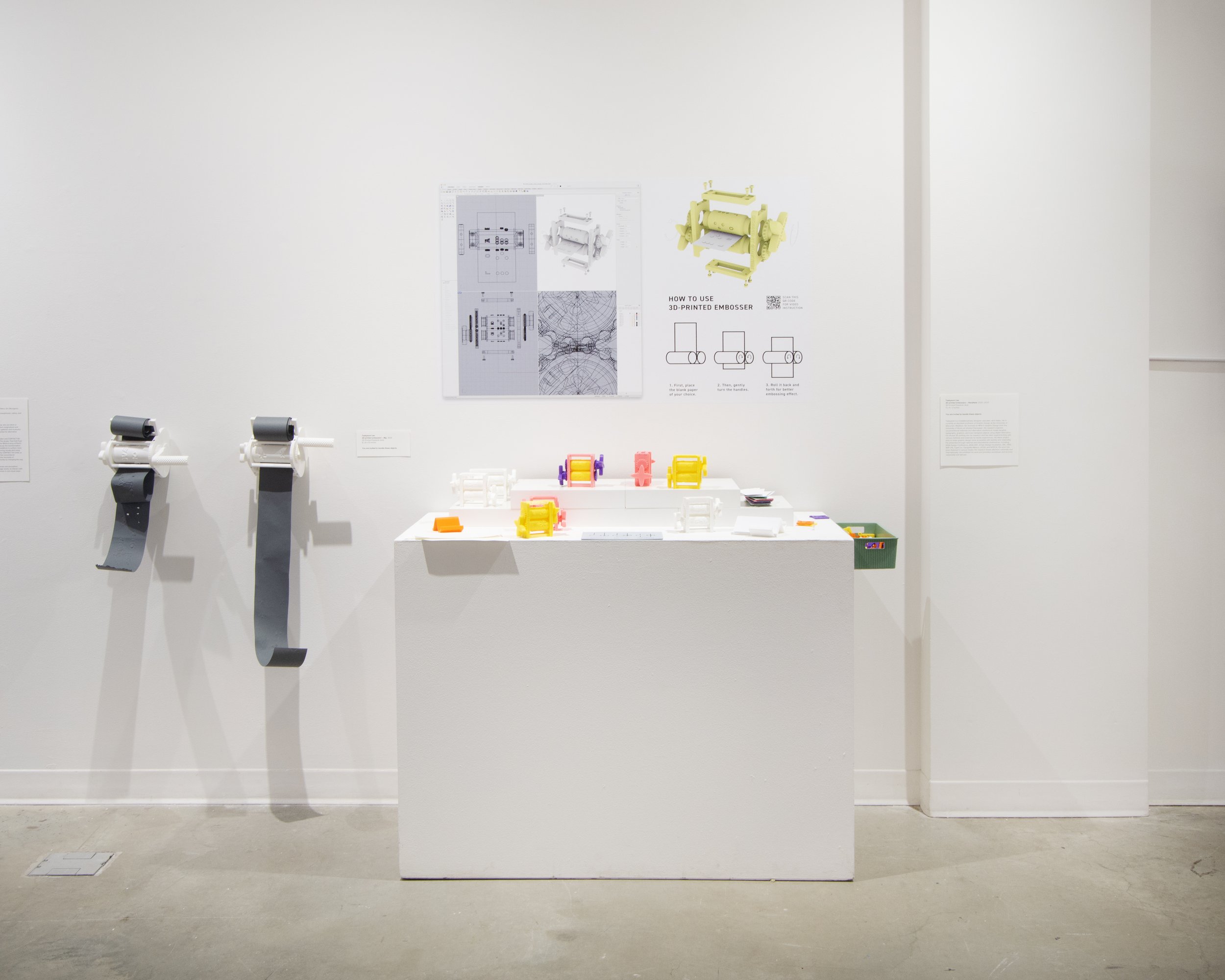 Disrupt and Resist gallery view of Taekyeom Lee installation with pedestal, graphics, and embossing machines
