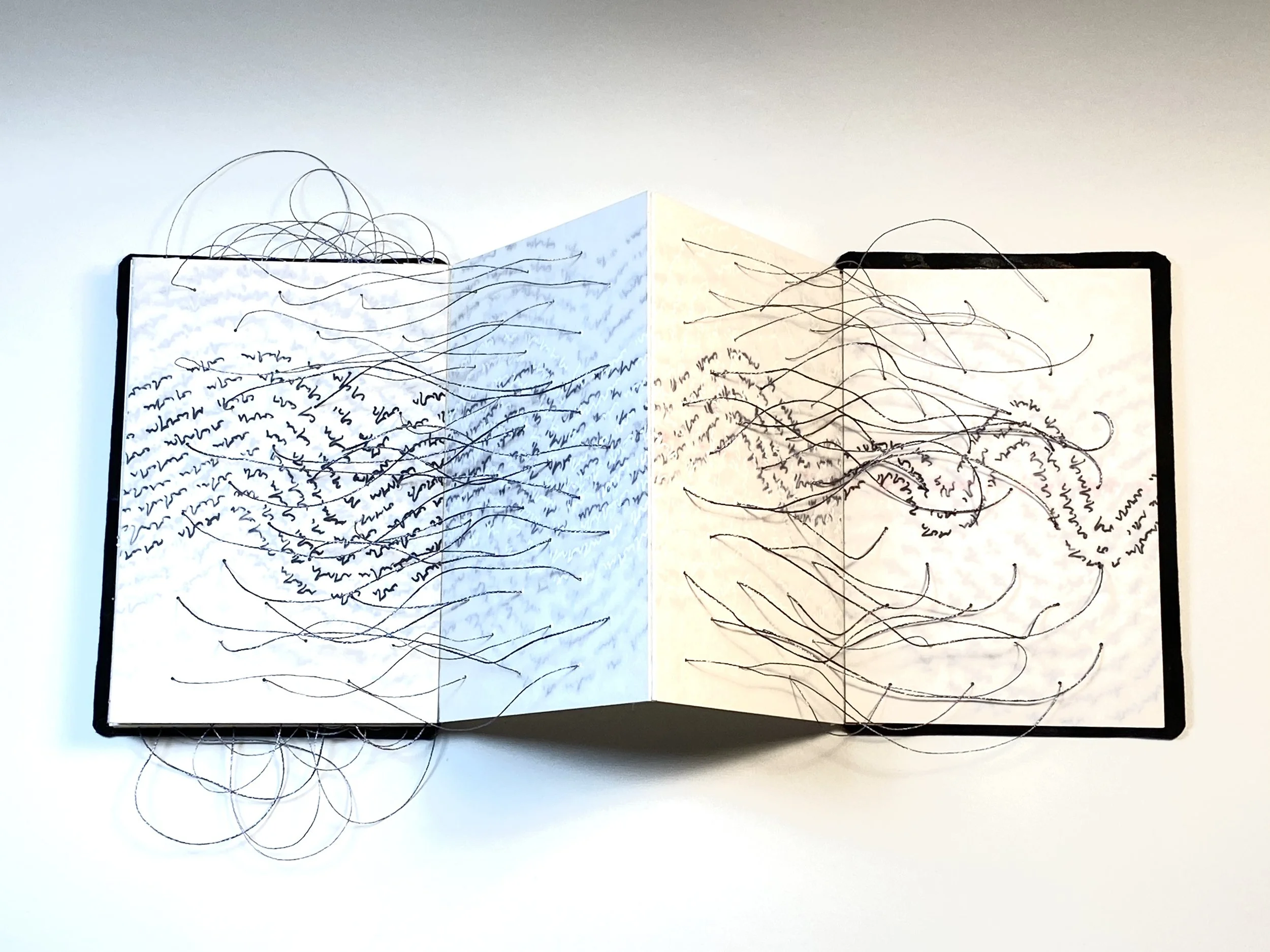 An open, tented artists' book with wave-like lines of black text and loose thread shot through the pages