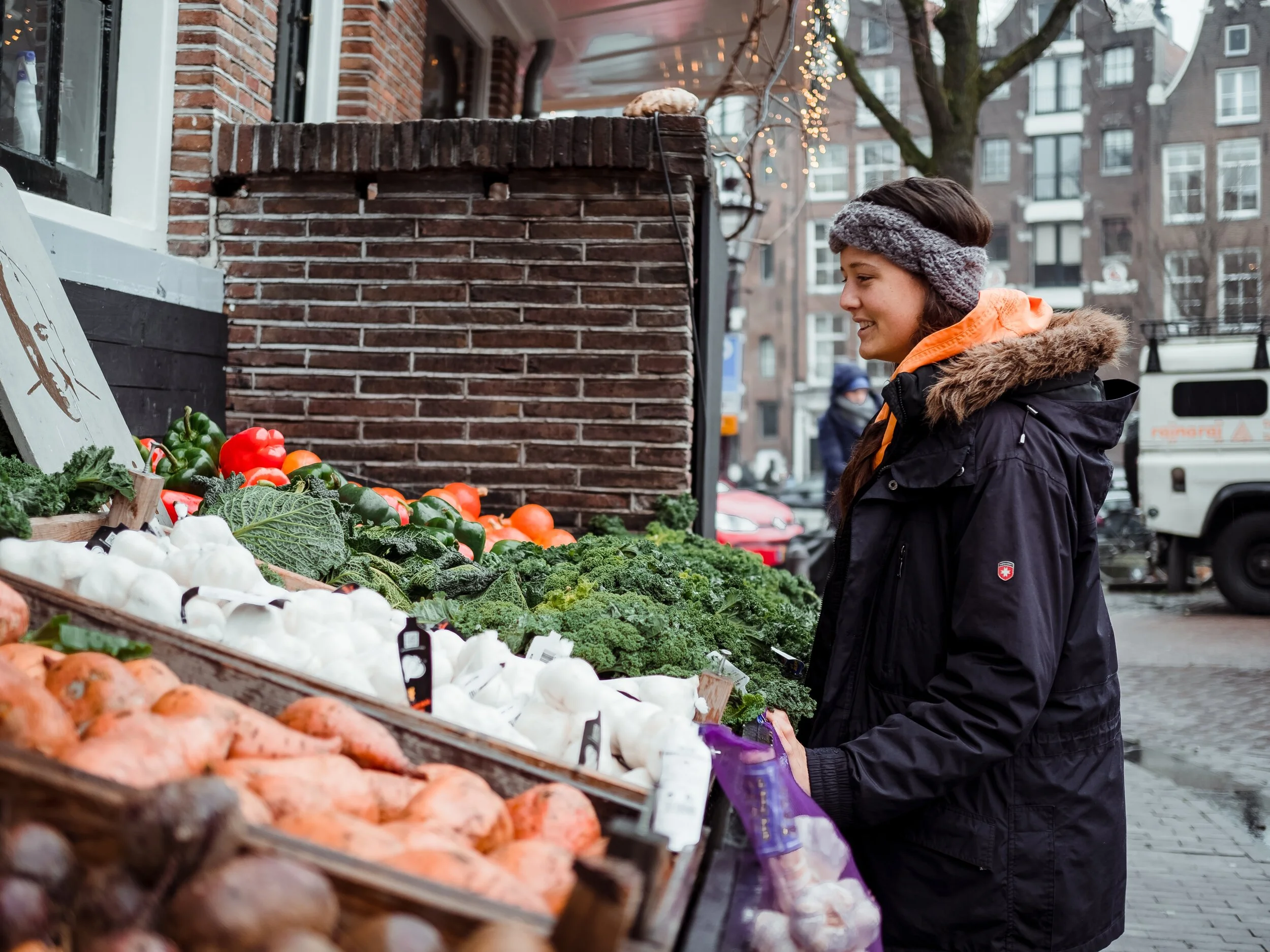 woman-standing-in-front-of-vegetable-stall-1884572.jpg