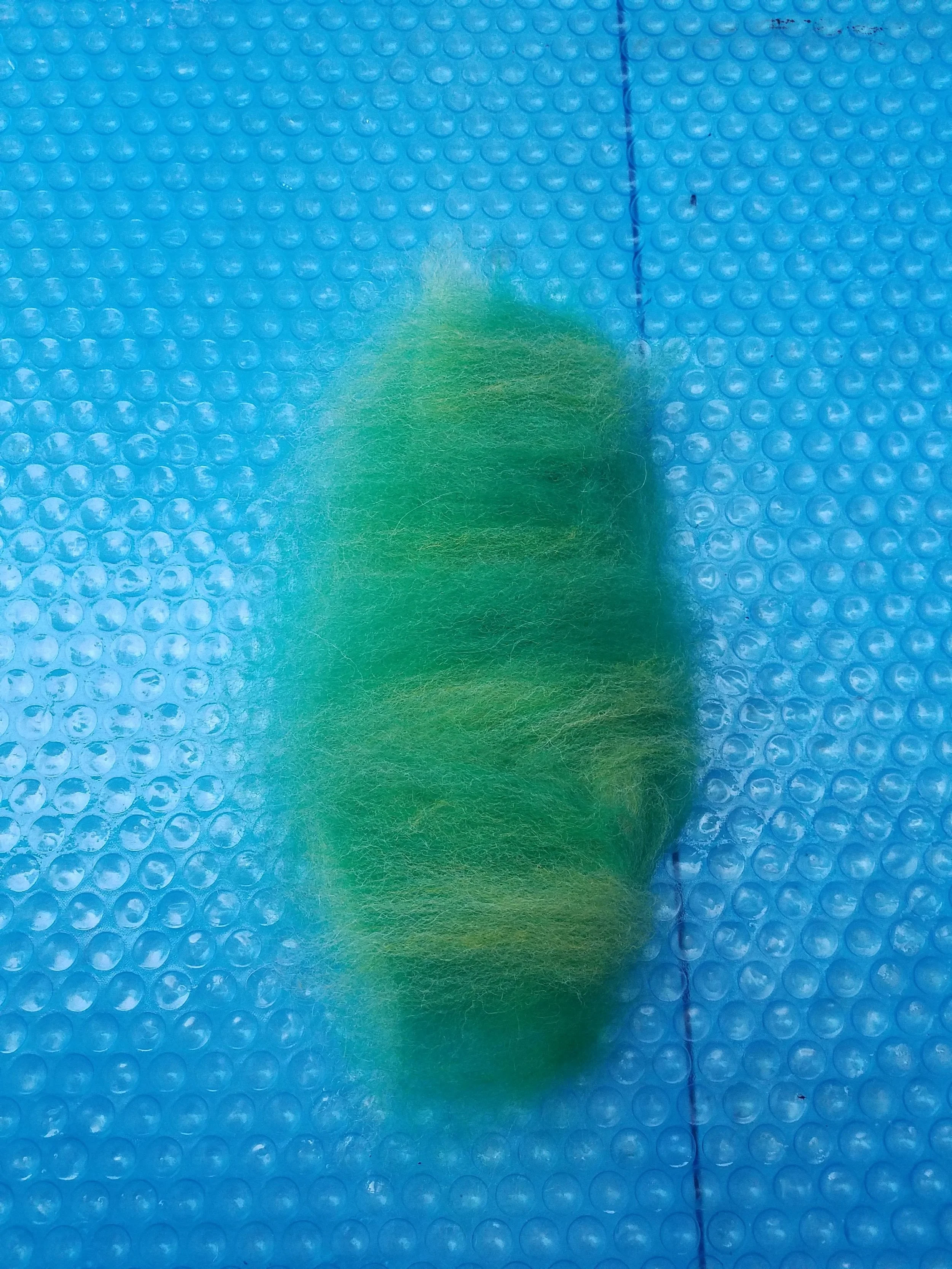 Once the size and shape of your piece is established, start your second layer. Continue pulling the roving apart into short thin pieces and begin to place them on top of the first layer. The pieces should be laid down going the opposite direction of the fibers in layer one. Layer two’s fibers should be going horizontally. Completely cover layer with layer two.