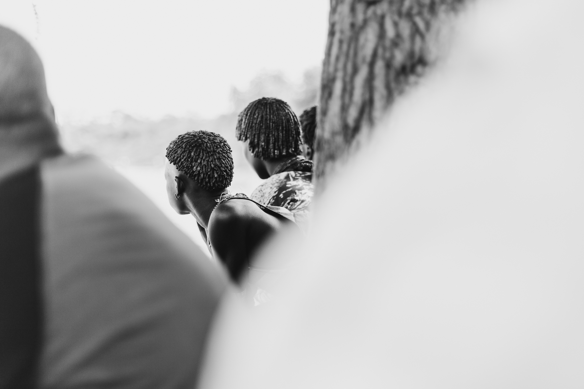 Women watch with mild interest as other women chase one of the whippers. They carry horns and bells that fill the air with a cacophony of music.