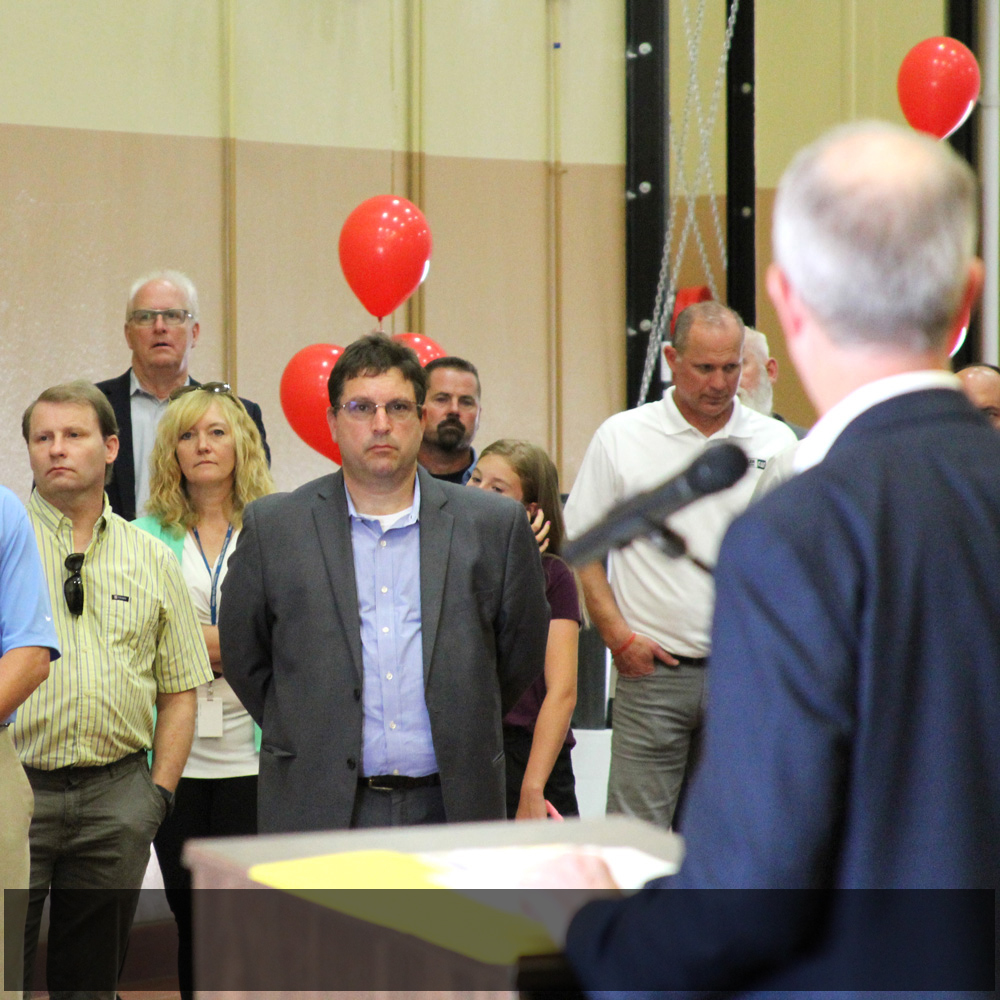   Caterpillar Power Generation Systems Regional Sales Director Claudio Martino listening intently along with others in the audience during the dedication ceremony.  