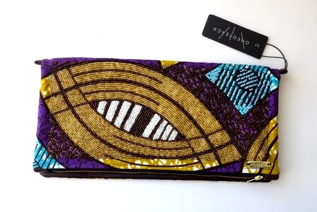 Beaded Ivory Coast print with brown ox hide South African handbag designer ONEOFEACH produces beautifully bright and unique fold-over clutch bags (which conveniently come with a strap so you can also wear it as a crossbody). The traditional print fabrics are sourced from around the continent and no two bags are the same. Visit ONEOFEACH