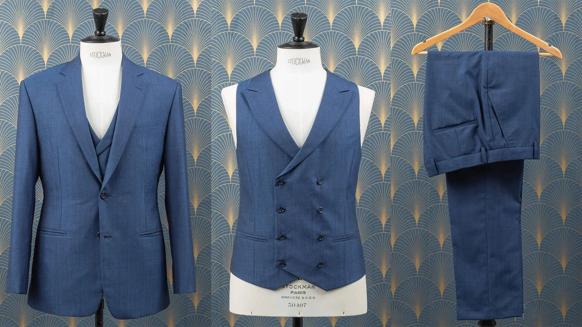 Driedelig blauw trouwpak op maat in Crispaire wol van Holland & Sherry: twee-knoops colbert met notch revers, double-breasted gilet met 4x2-knoopsluiting en peak revers, en maatbroek met omslag