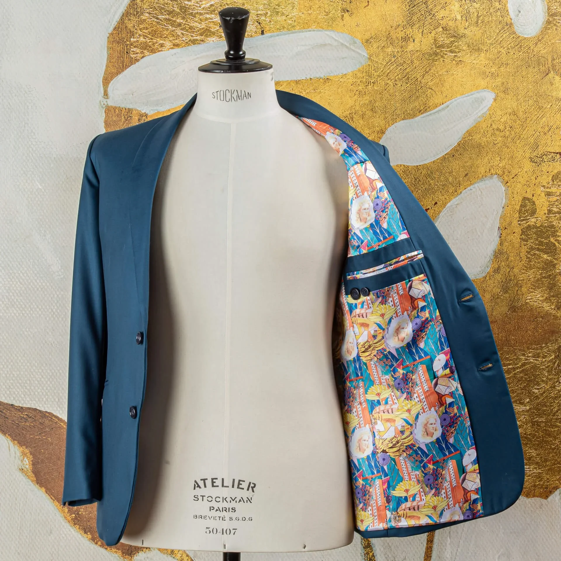 Petrol blauw bespoke colbert geopend, toont kleurrijke Art Deco dessin voering en full canvas constructie