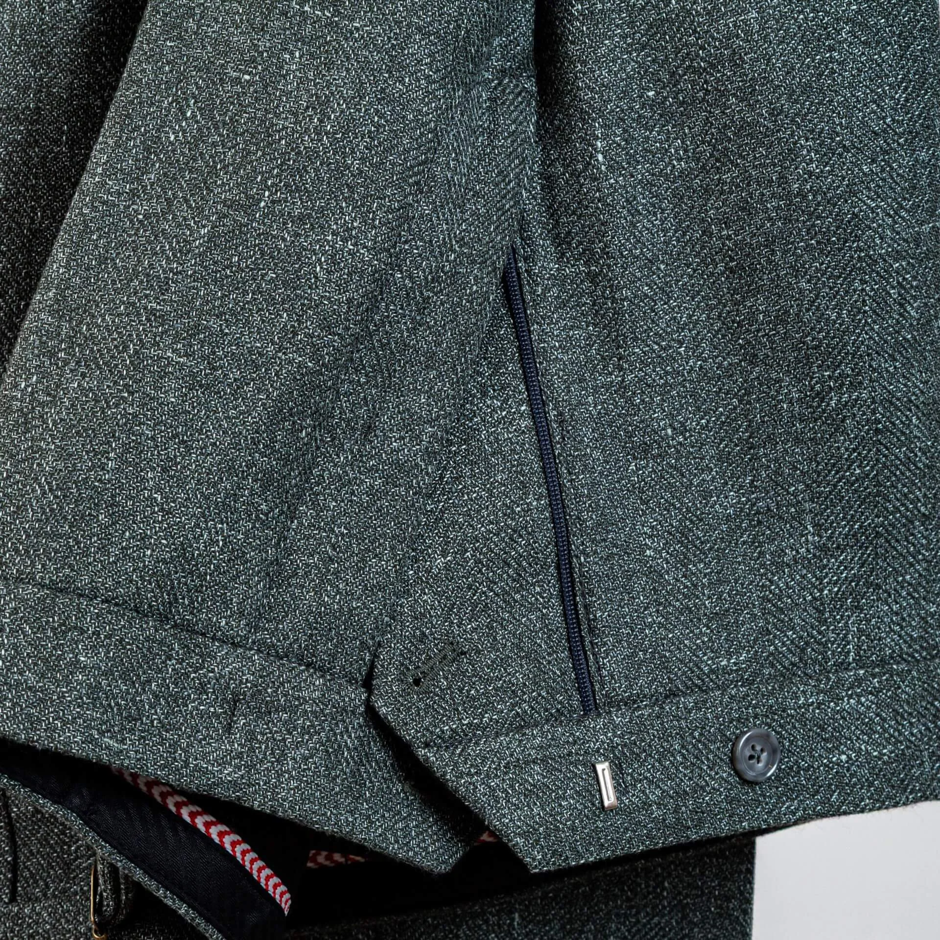 Detail gulpsluiting van groene bespoke pantalon tonen traditionele ambachtelijke afwerking.