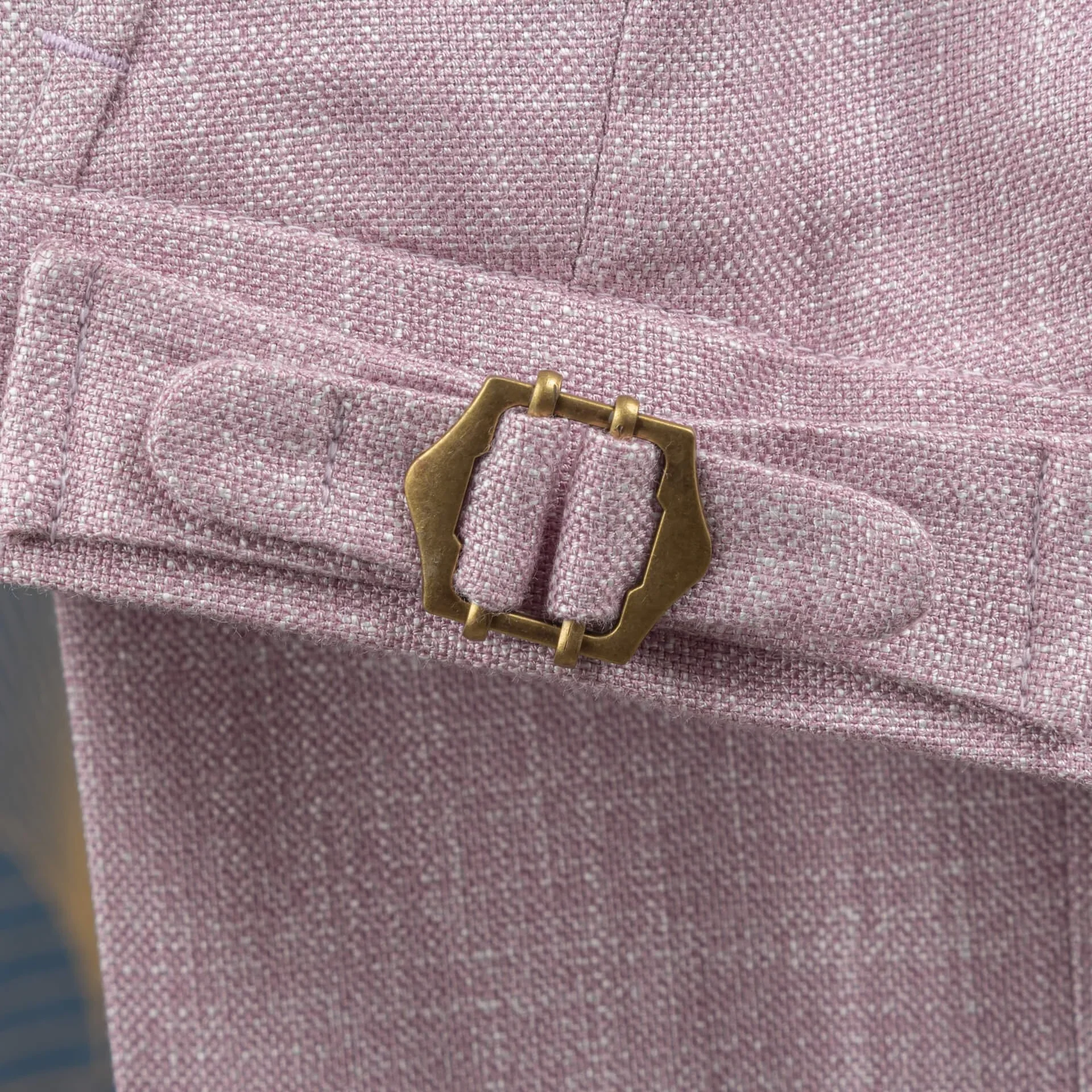 Close-up van antiek messing side-adjuster gesp op roze bamboe pantalon, geen riemlussen