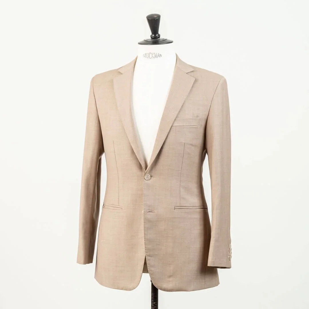 Driekwart aanzicht van zandkleurig bespoke trouwcolbert met relaxte pasvorm en Spalla Camicia schouder voor strandbruiloft