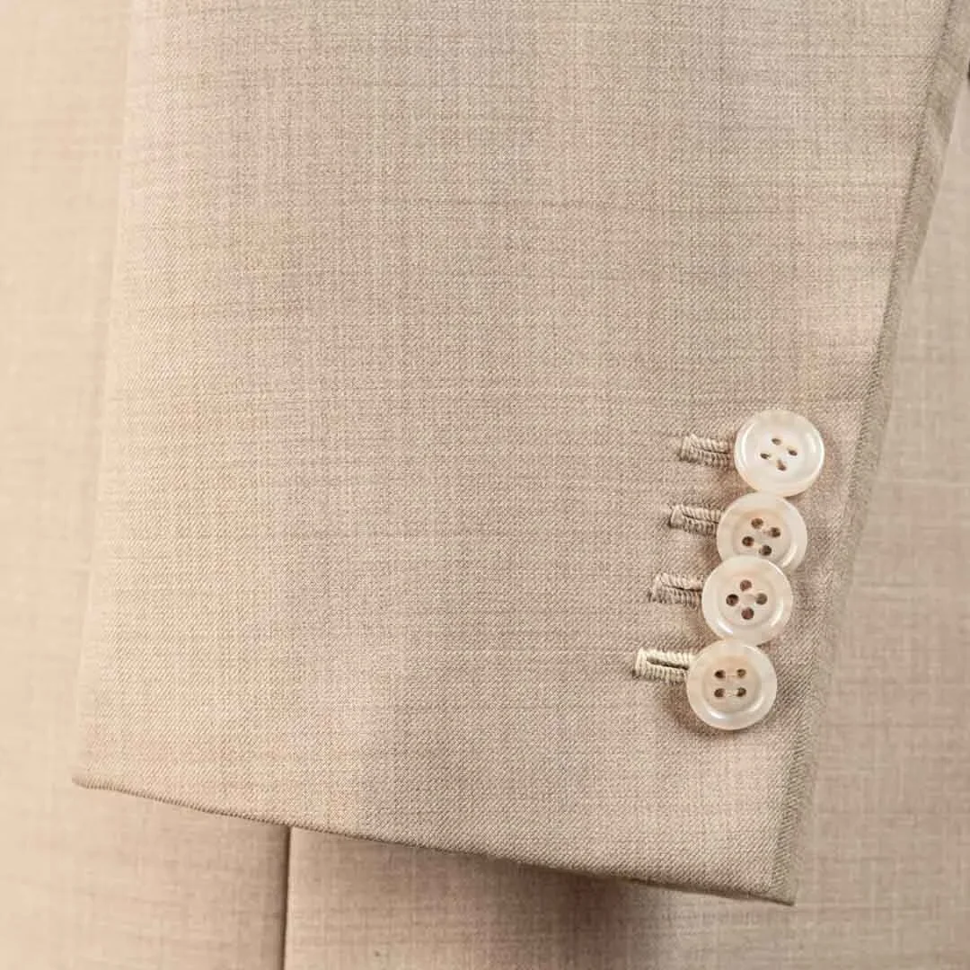 Vier kissing buttons met werkende knoopsgaten op de mouw van zandkleurig bespoke zomer trouwpak, parelmoeren knopen als kenmerk van maatwerk