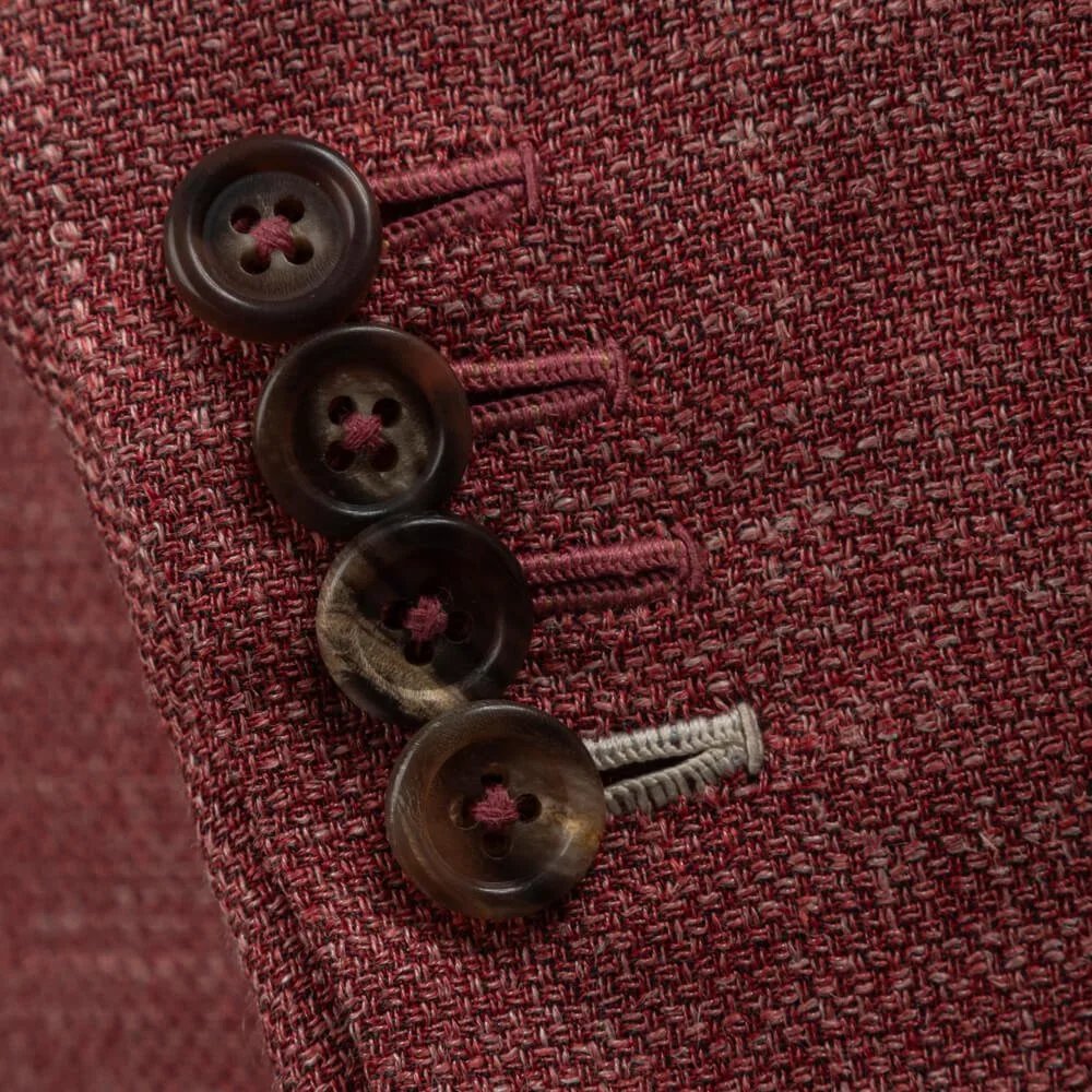 Vier werkende manchetknoopsgaten op roze colbert, kenmerk van echte bespoke maatwerk