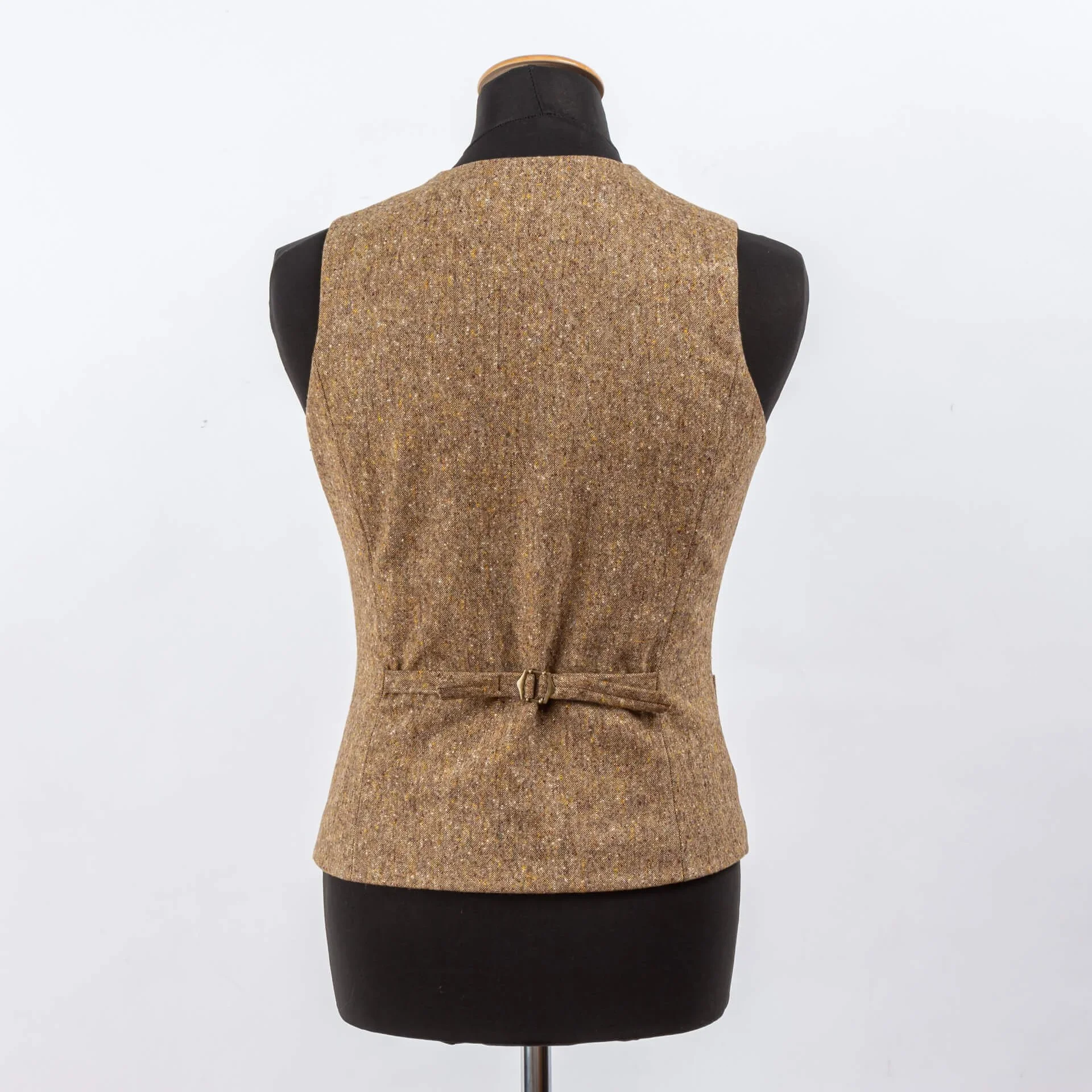 Asymmetrisch goudbruin Donegal tweed gilet rugaanzicht met verstelbare rugband en vintage gesp, textuur en knaps zichtbaar