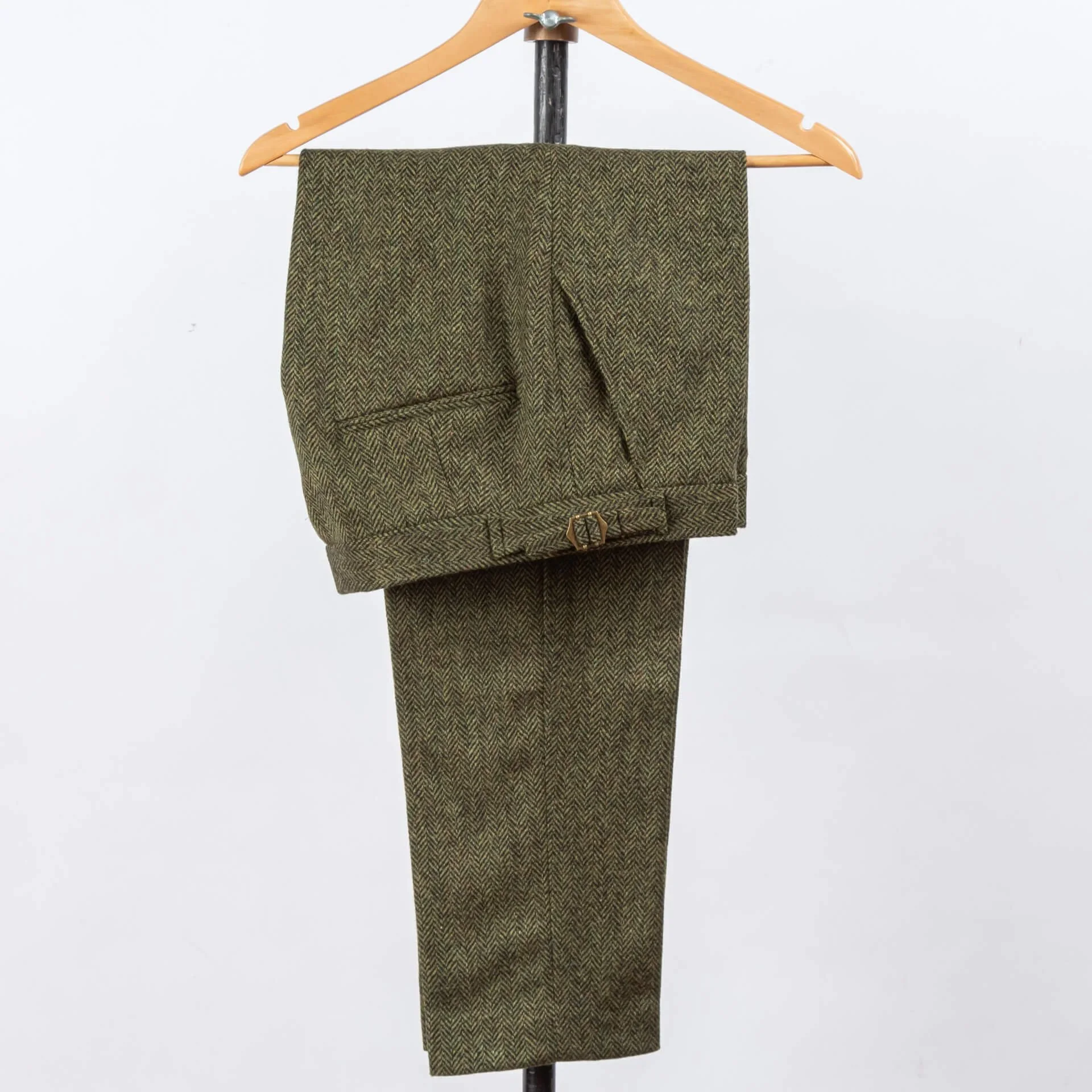 Olijfgroen tweed broek op maat met visgraatpatroon, volledig overzicht hangend op hanger, matching stof met colbert