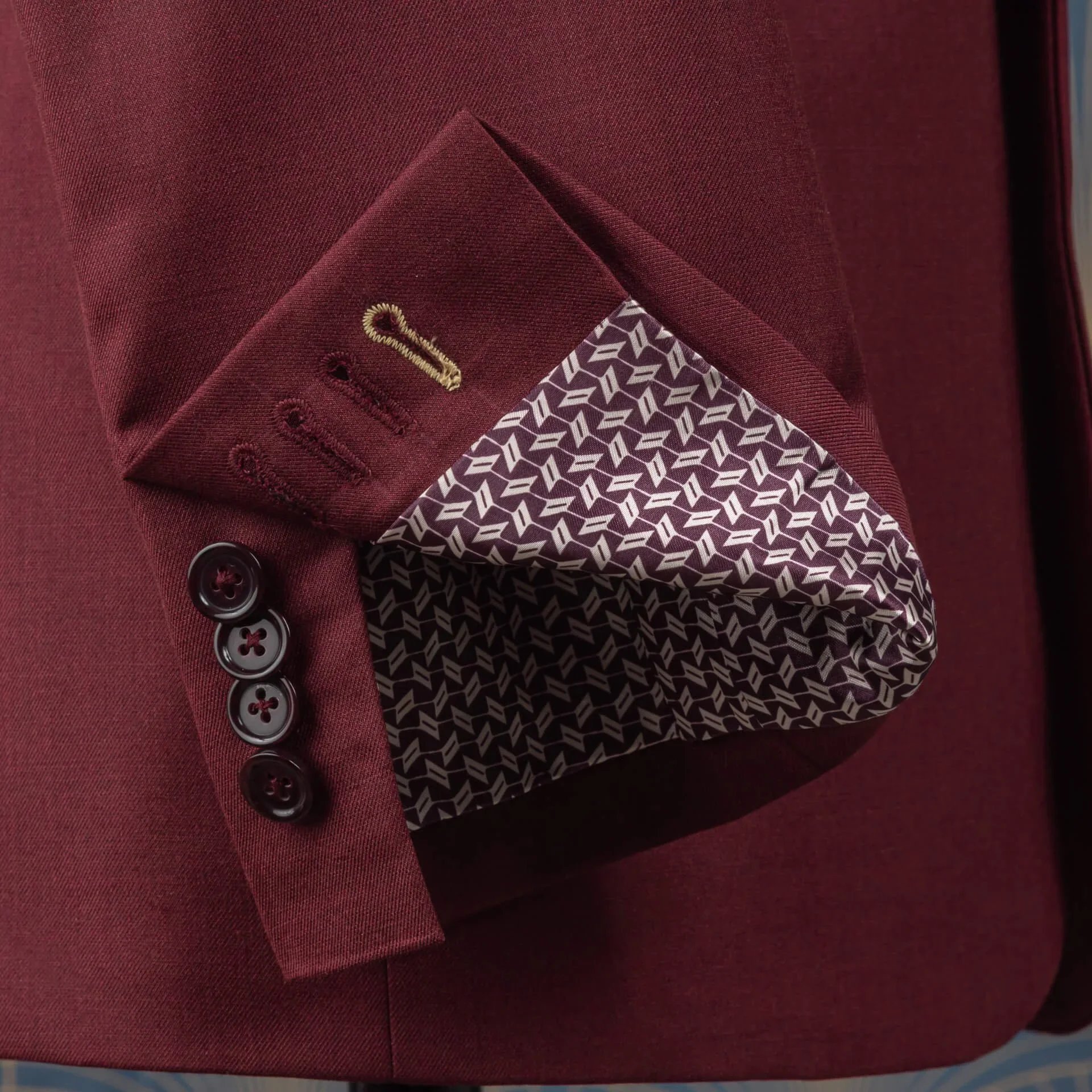 Vier kissing buttons op handgemaakt manchet met goudgeel accent knoopsgat en bordeaux wit geometrisch voeringspatroon