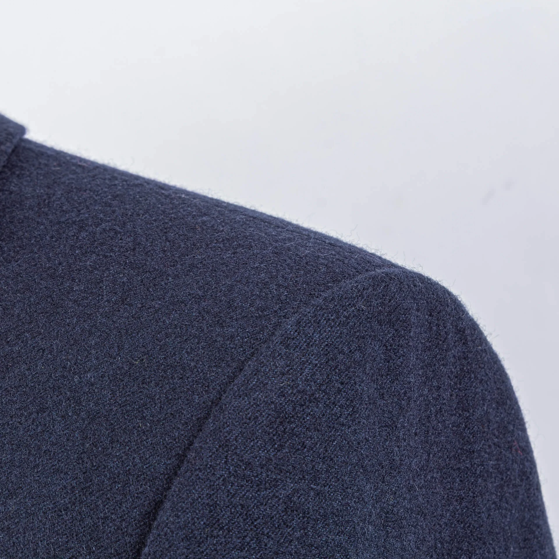 Detail van natuurlijke schouderconstructie blue melange colbert, clean lijnen zonder opvulling, klassiek Brits maatwerk