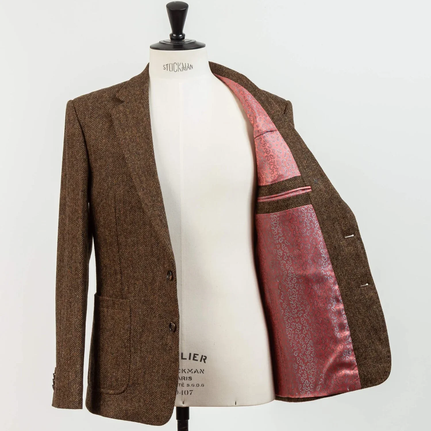 Brown herringbone tweed colbert open met roze paisley voering, onverwacht kleurdetail onder stoere tweed, vintage Savile Row stijl, okergeel gilet zichtbaar