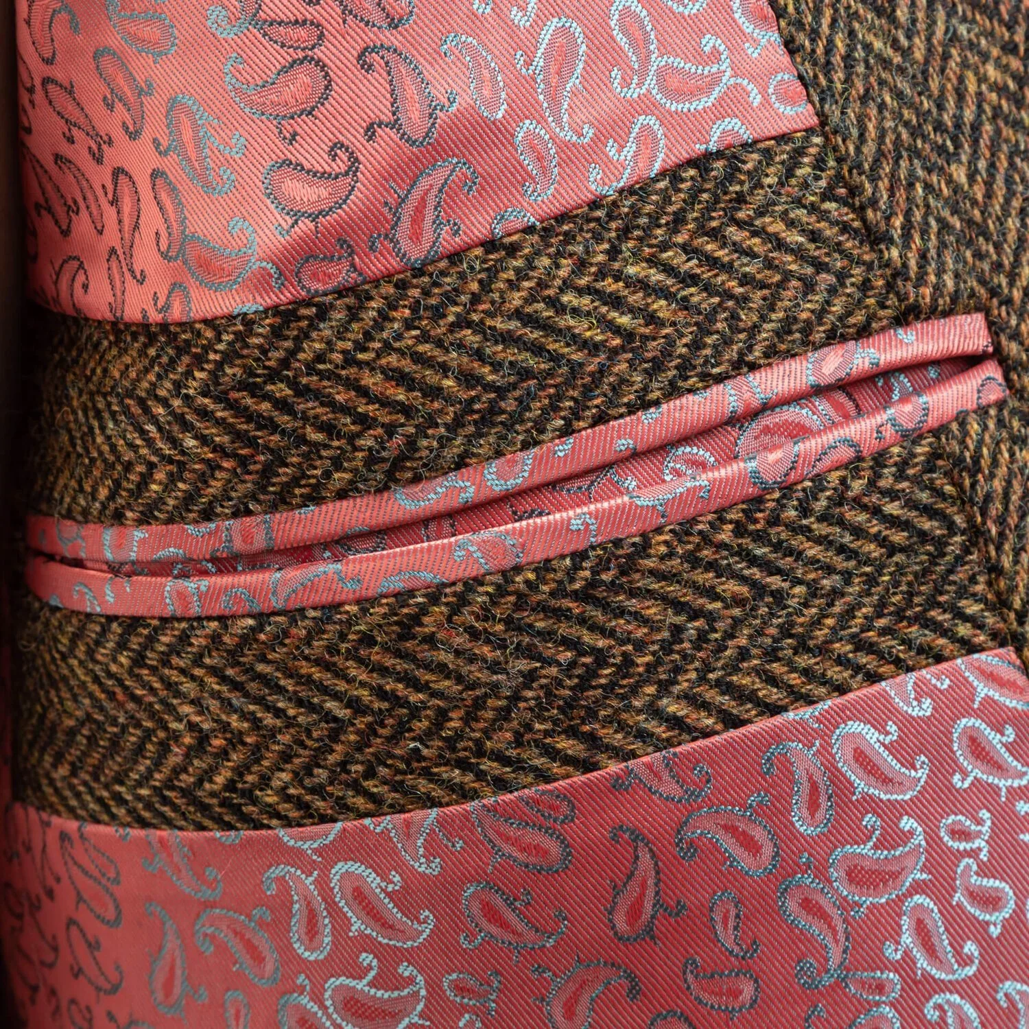 Brown herringbone tweed colbert open met roze paisley voering, onverwacht kleurdetail onder stoere tweed, vintage Savile Row stijl, okergeel gilet zichtbaar