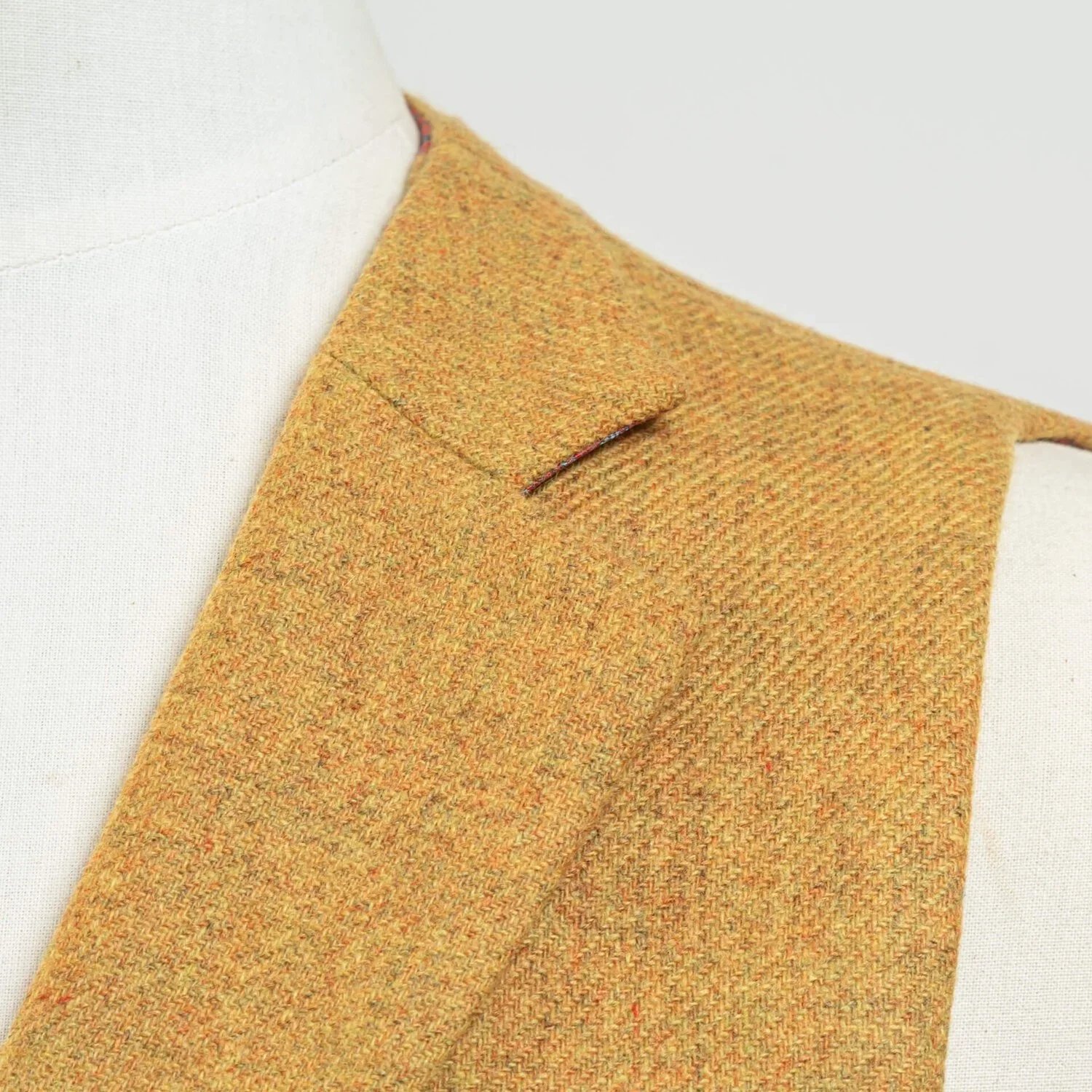 Close-up notch lapel van okergeel twill lapel met subtiele diagonale weefstructuur, 300 gram Bateman Ogden stof, notch lapel detail vintage gilet