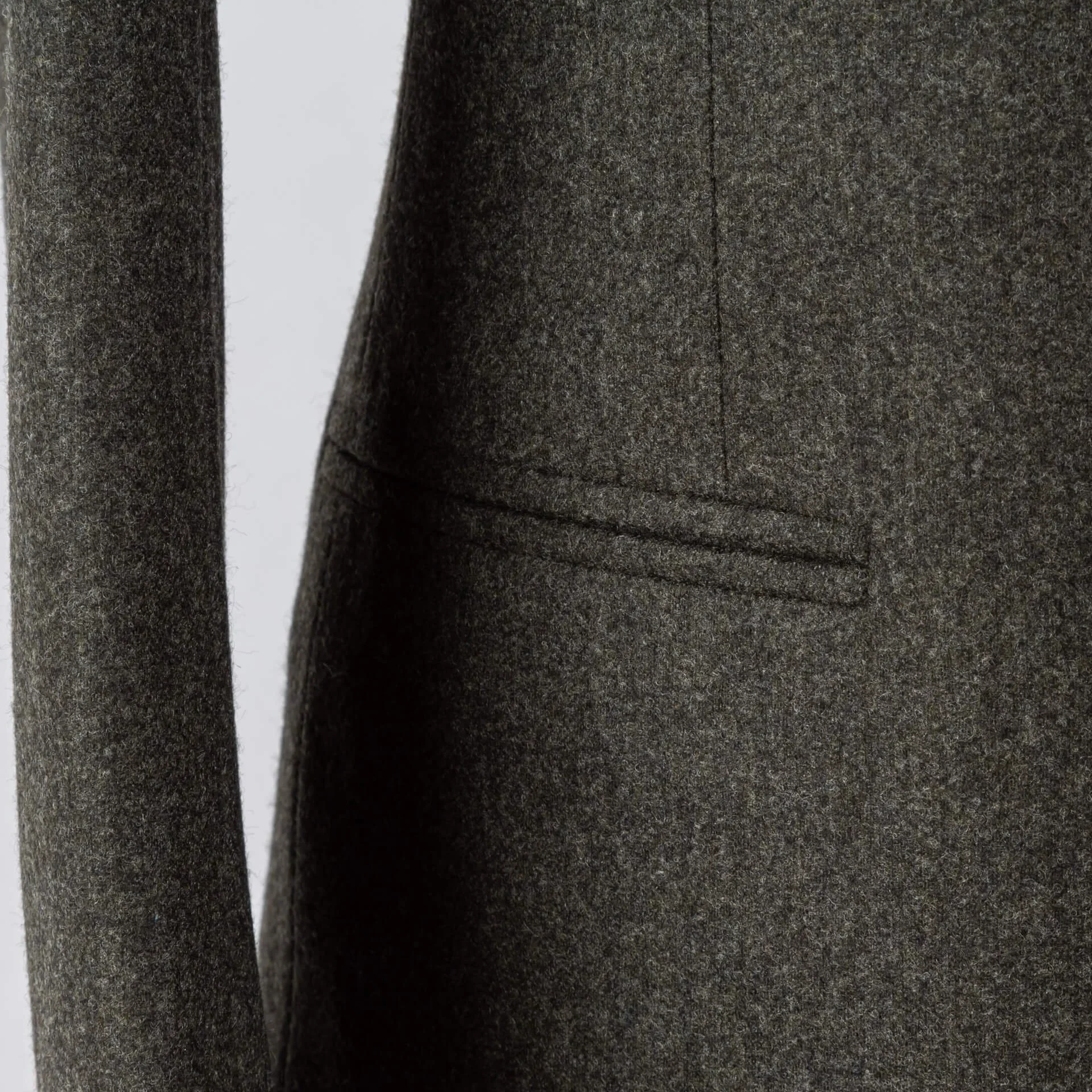 Paspelzak detail op forest green flannel colbert, clean silhouet