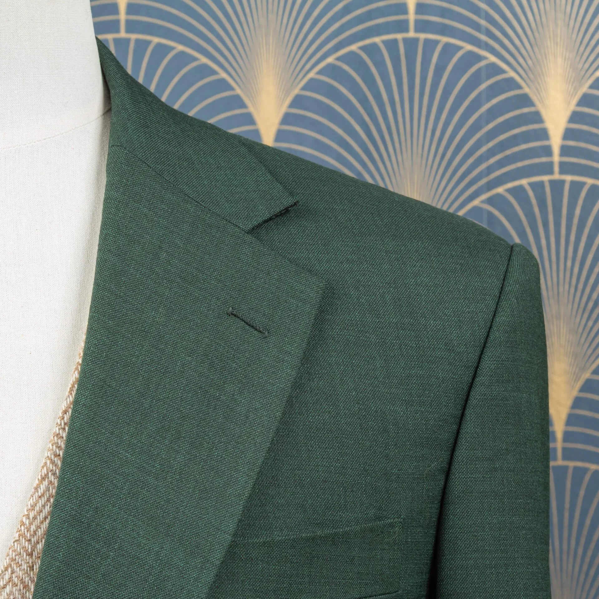 Close-up van notch lapel en schouderconstructie van saffiergroen merino wol trouwpak, toont de subtiele sharkskin weving en handgemaakte knoopsgat op de revers