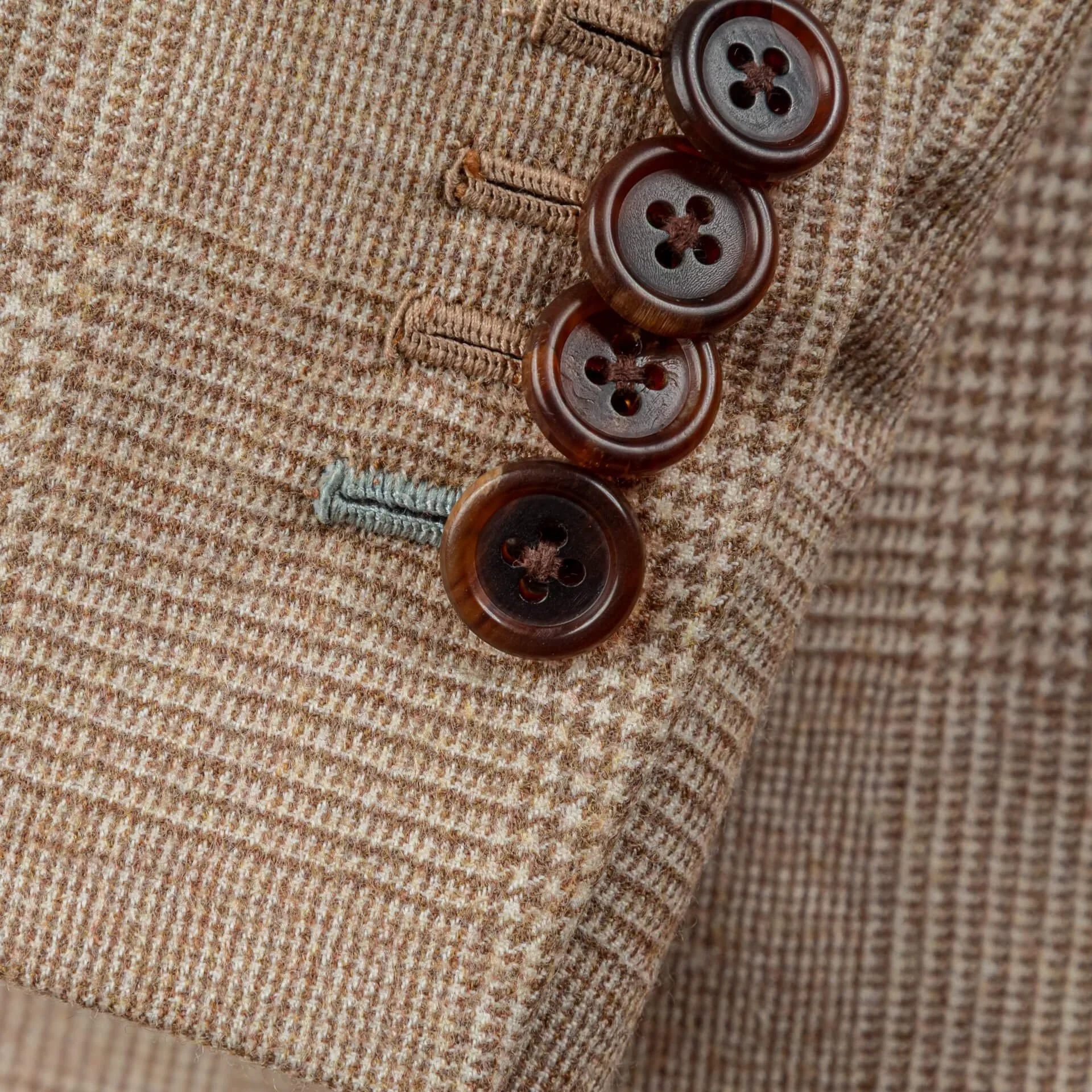 Close-up van vier kissing buttons op mouw met onderste knoopsgat in giletkleur duck egg blue