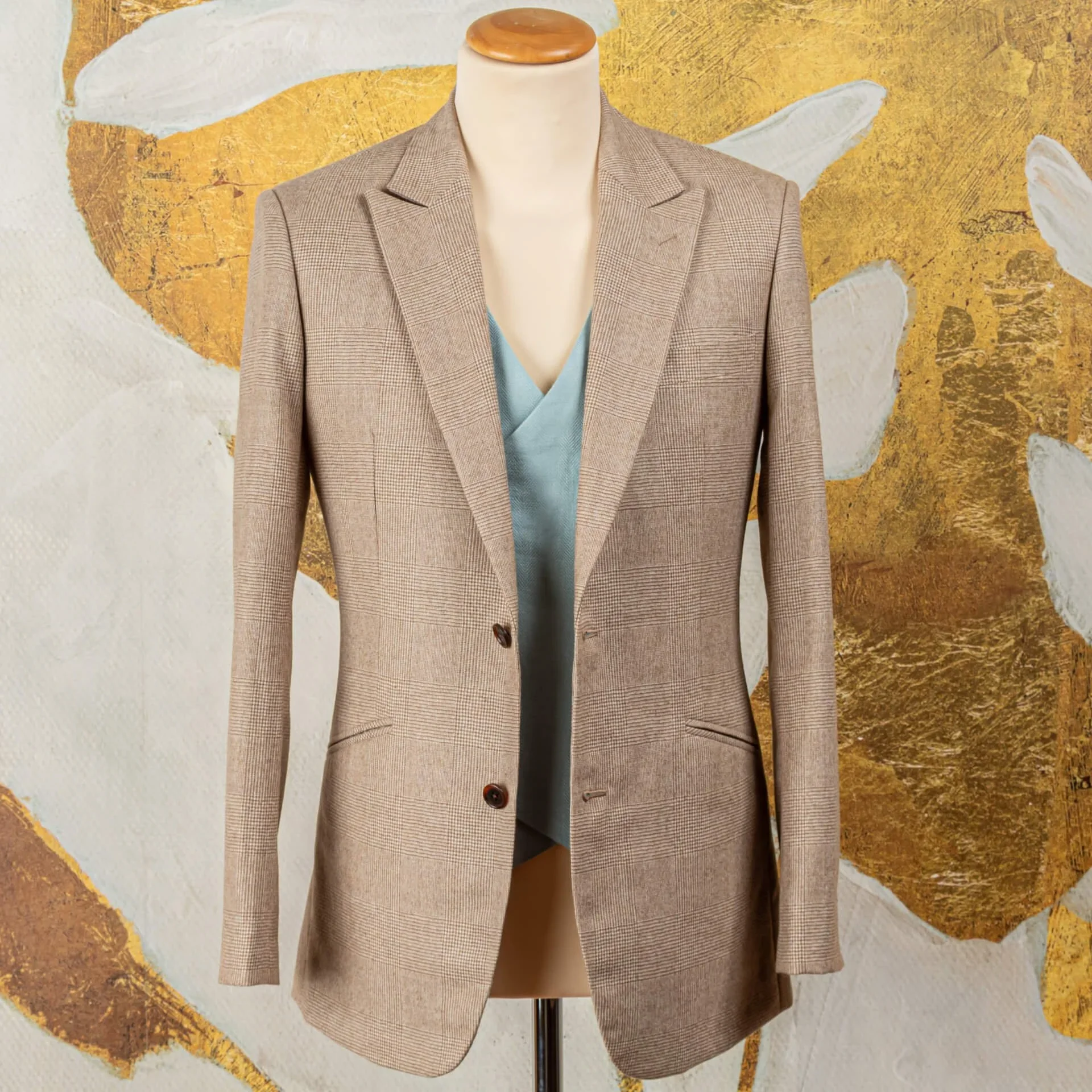 Bespoke trouwpak colbert in camel check worsted flannel van Fox Brothers met peak lapels en blauw linnen gilet, vooraanzicht op paspop