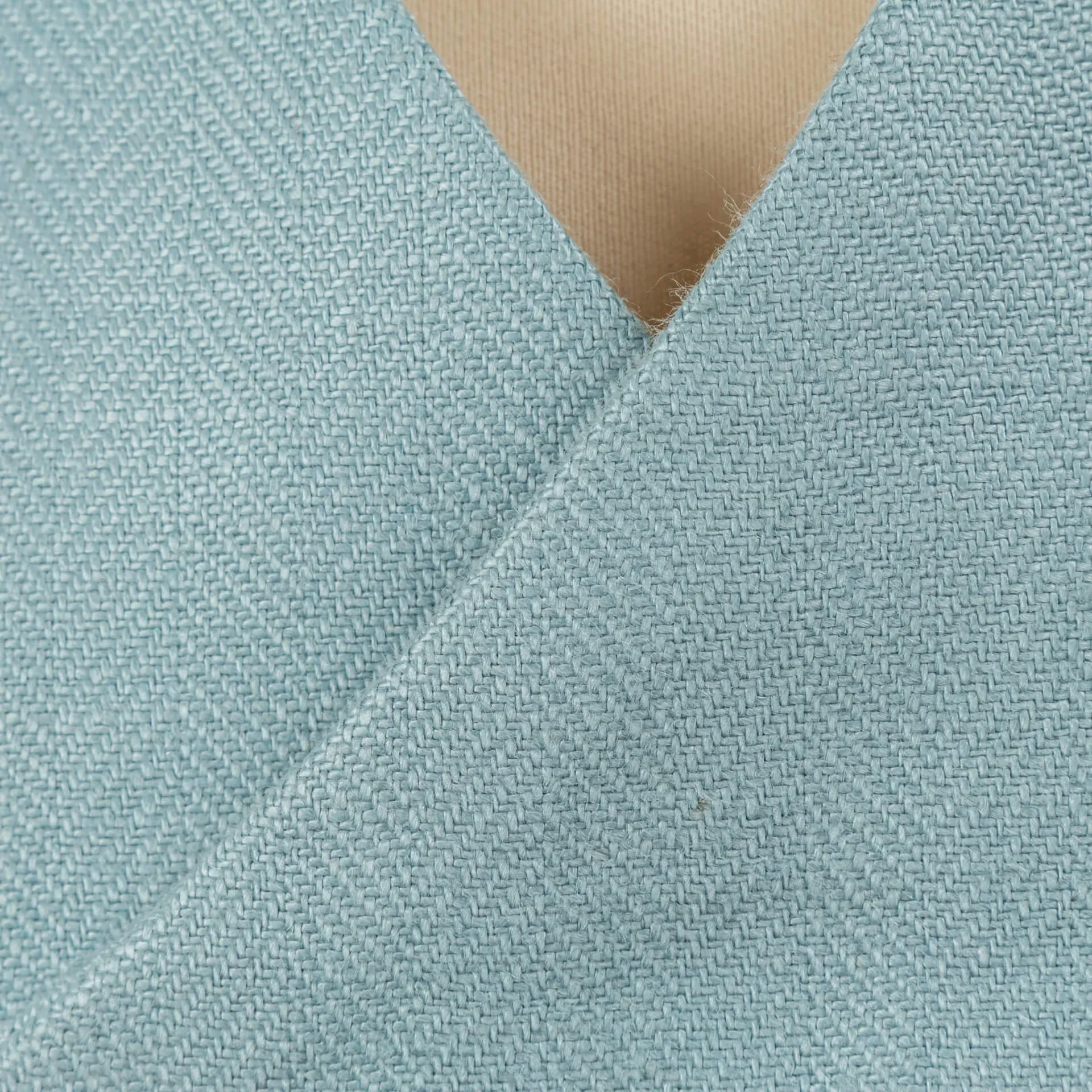 Close-up van Iers linnen weefsel in duck egg blue, toont karakteristieke textuur en subtiele glans