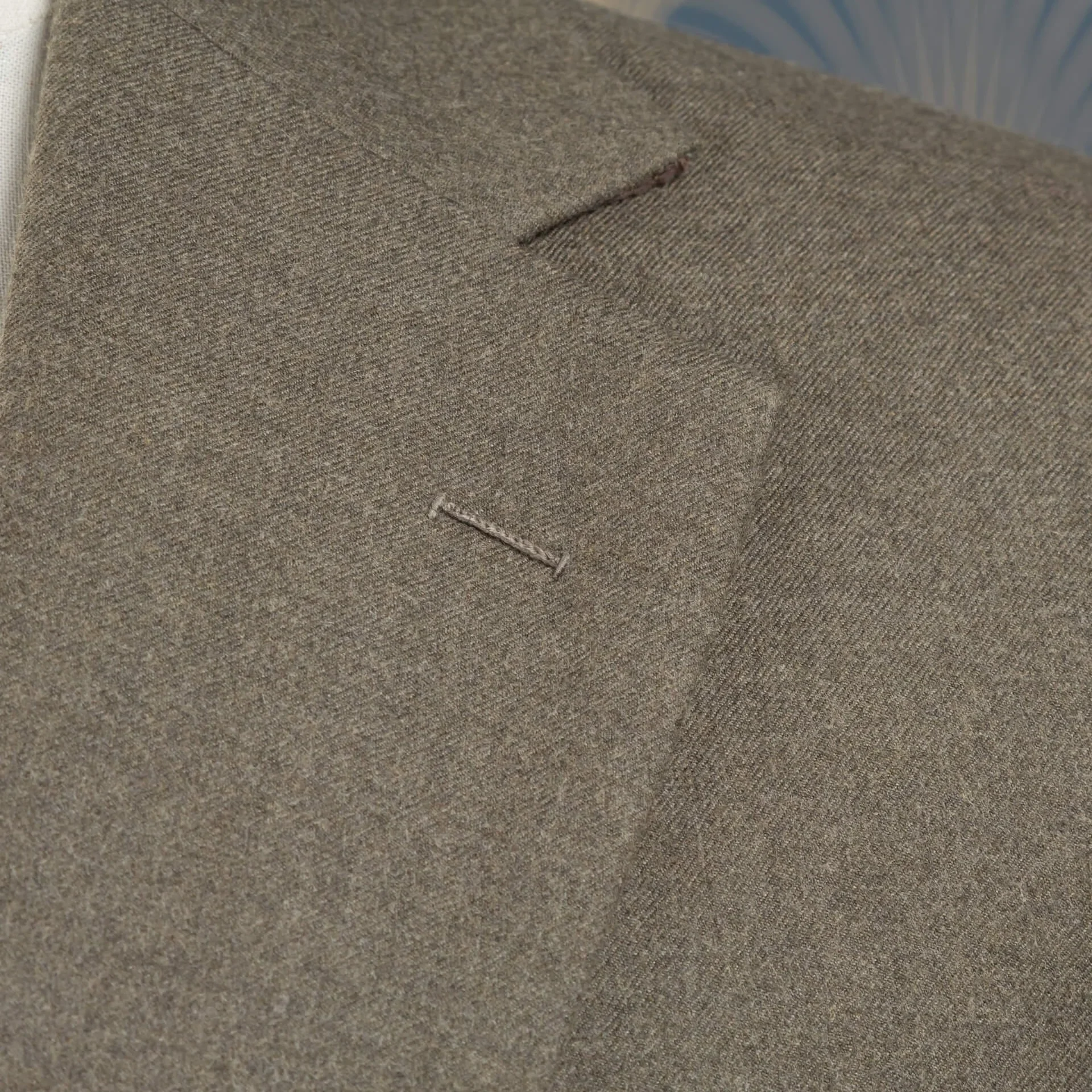 Close-up van handgestikte flowerloop op notch lapel in oatmeal S140's worsted flannel