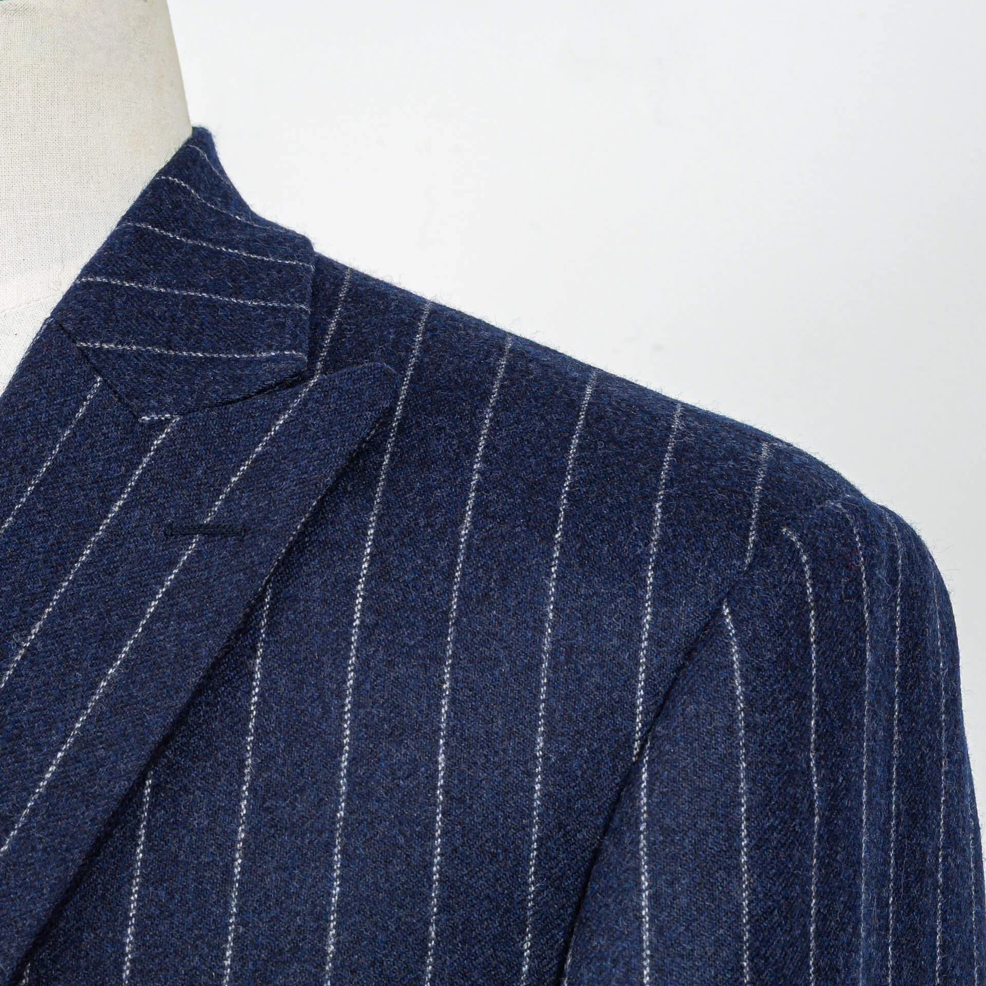 Close-up van Spalla Camicia schouder met subtiele shirring op navy krijtstreep flannel colbert, toont Napolitaans vakmanschap