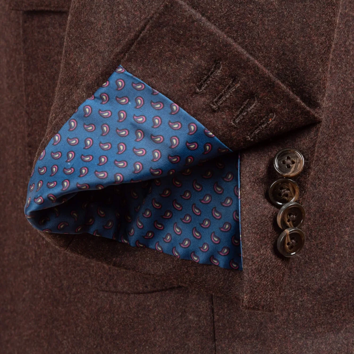 Werkende manchet met blauwe paisley voering en hoornen knopen