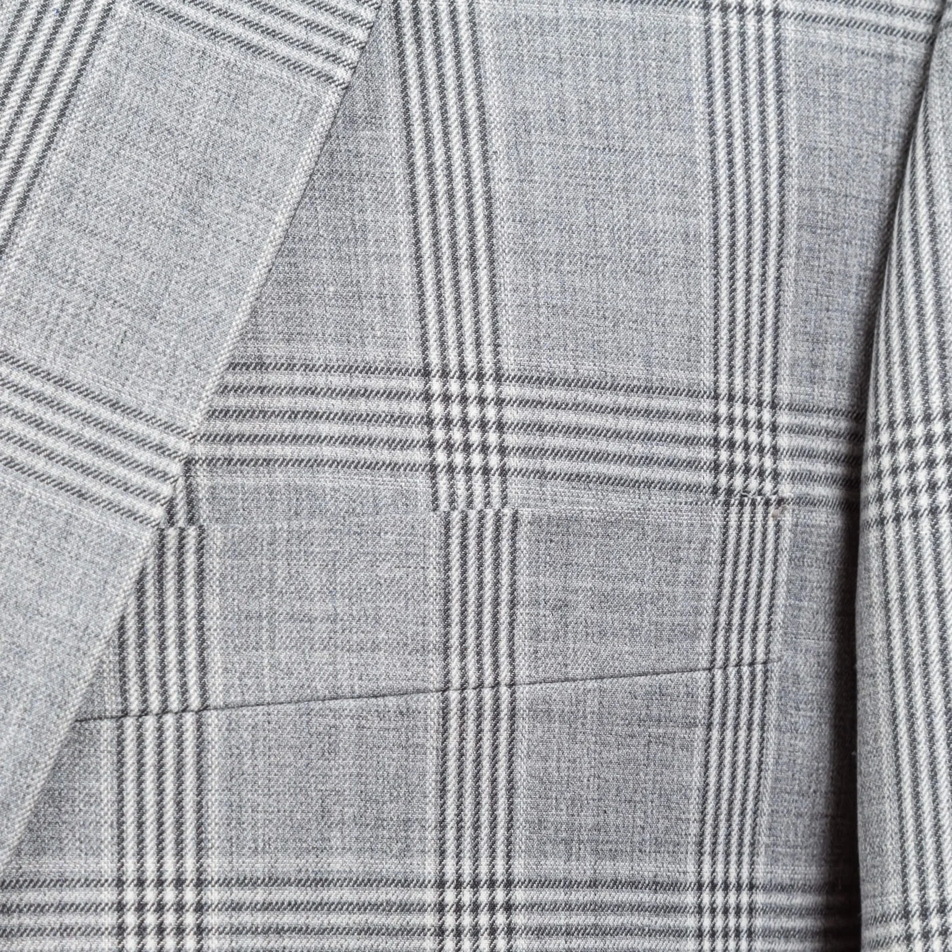 Detail van lapel en borstzak met naadloos doorlopend ruitpatroon