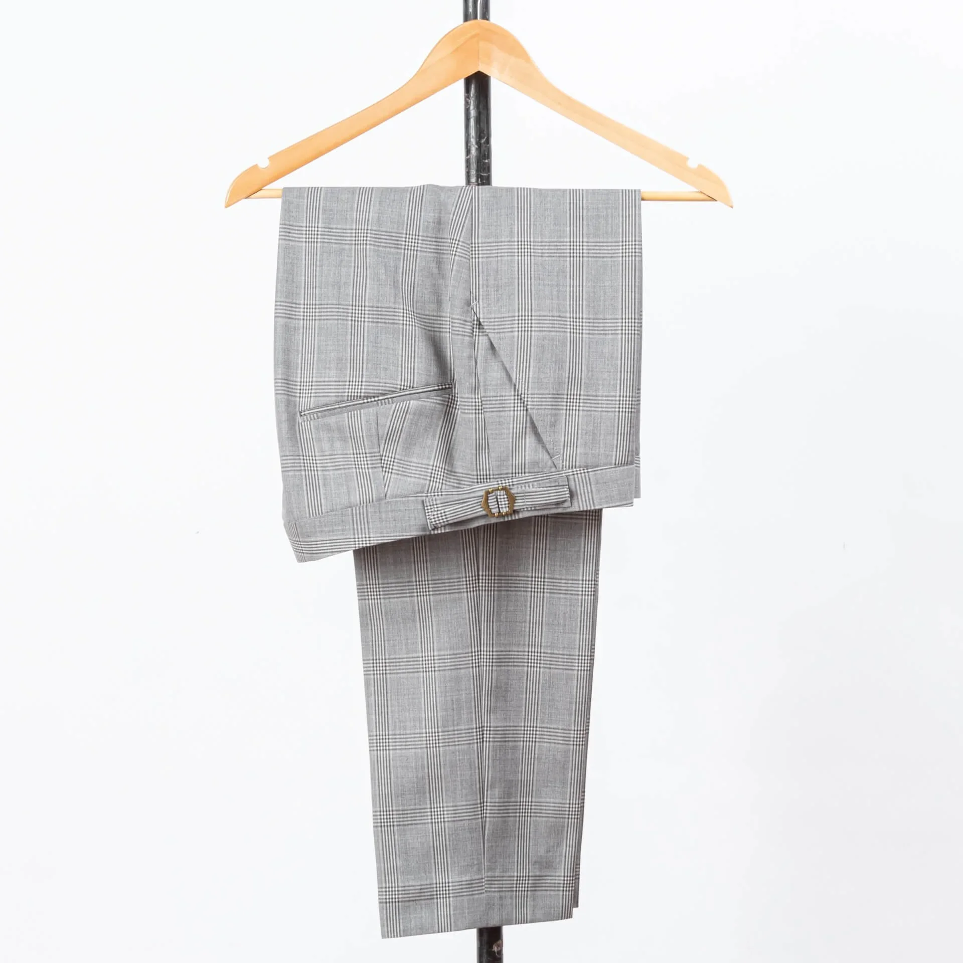 Lichtgrijze geruite pantalon met messing side adjusters op houten kledinghanger