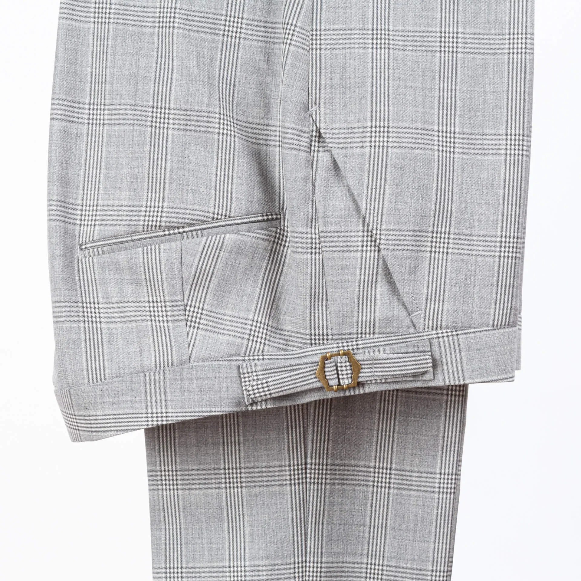 Detail van tailleband met messing side adjuster gesp op geruite pantalon