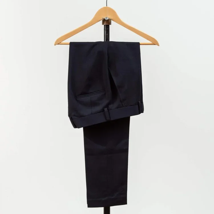 Navy wollen pantalon met riemlussen op kledinghanger, paspelzak achter zichtbaar