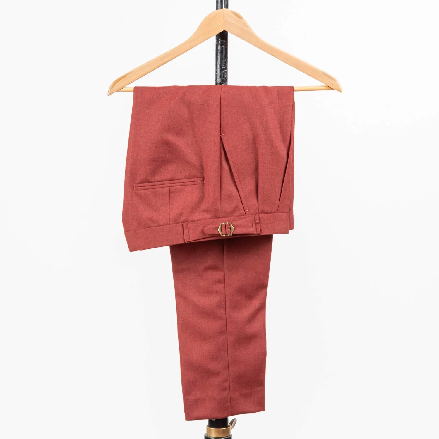 Terracotta broek op maat op hanger, met dubbele bandplooi en side adjusters met bronzen gesp.