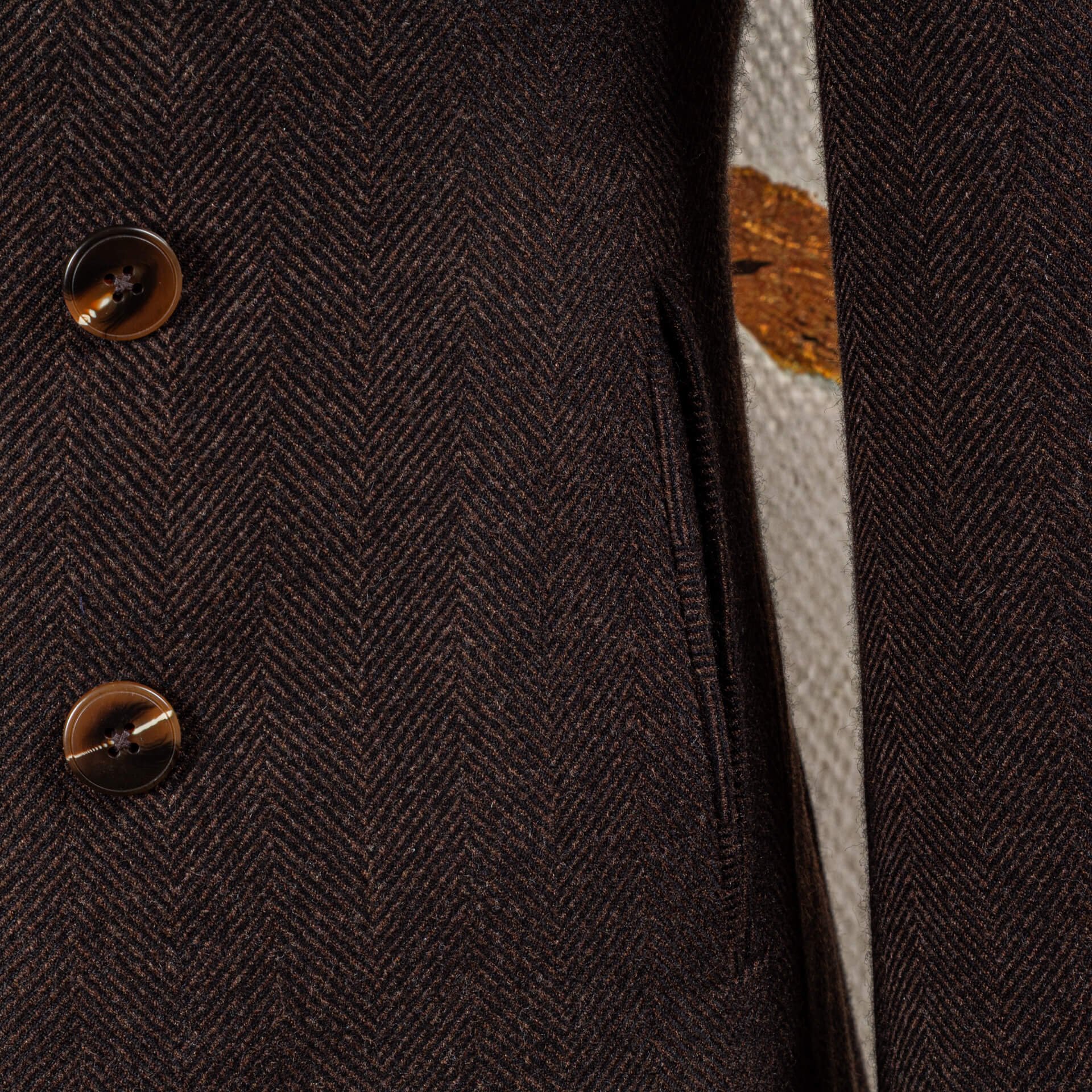 Paspelzak en hoornen knopen op herringbone peacoat detail