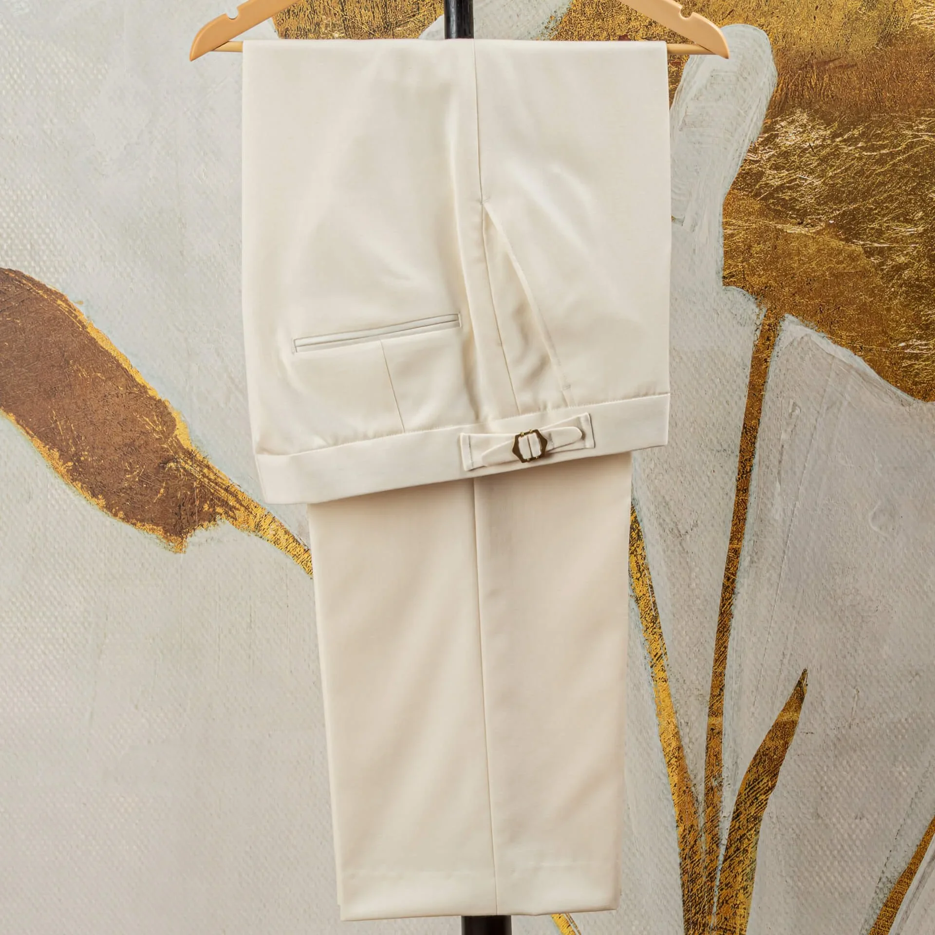 Gevouwen witte pantalon in barathea met steekzak en zijspanner met goudkleurige buckle op de tailleband, trouwpak op maat in Holland & Sherry Black Tie barathea van 370 gram