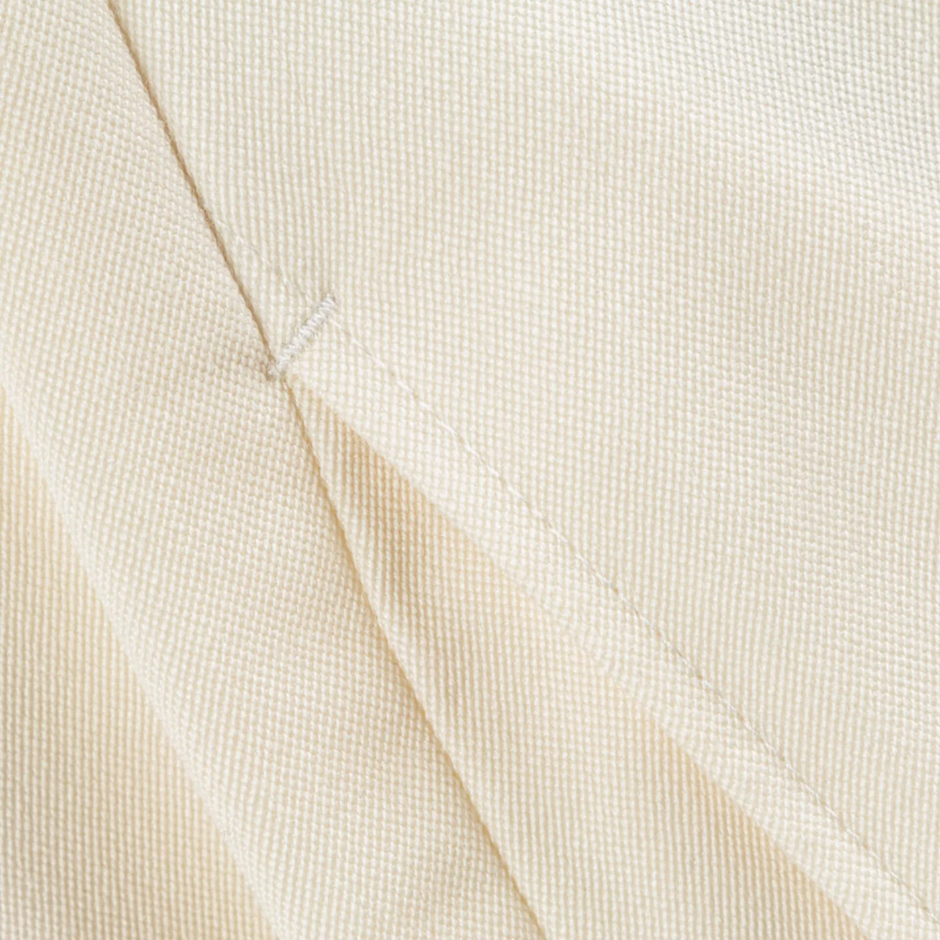 Close-up van een naad in witte barathea van de pantalon, trouwpak op maat in Holland & Sherry Black Tie barathea van 370 gram